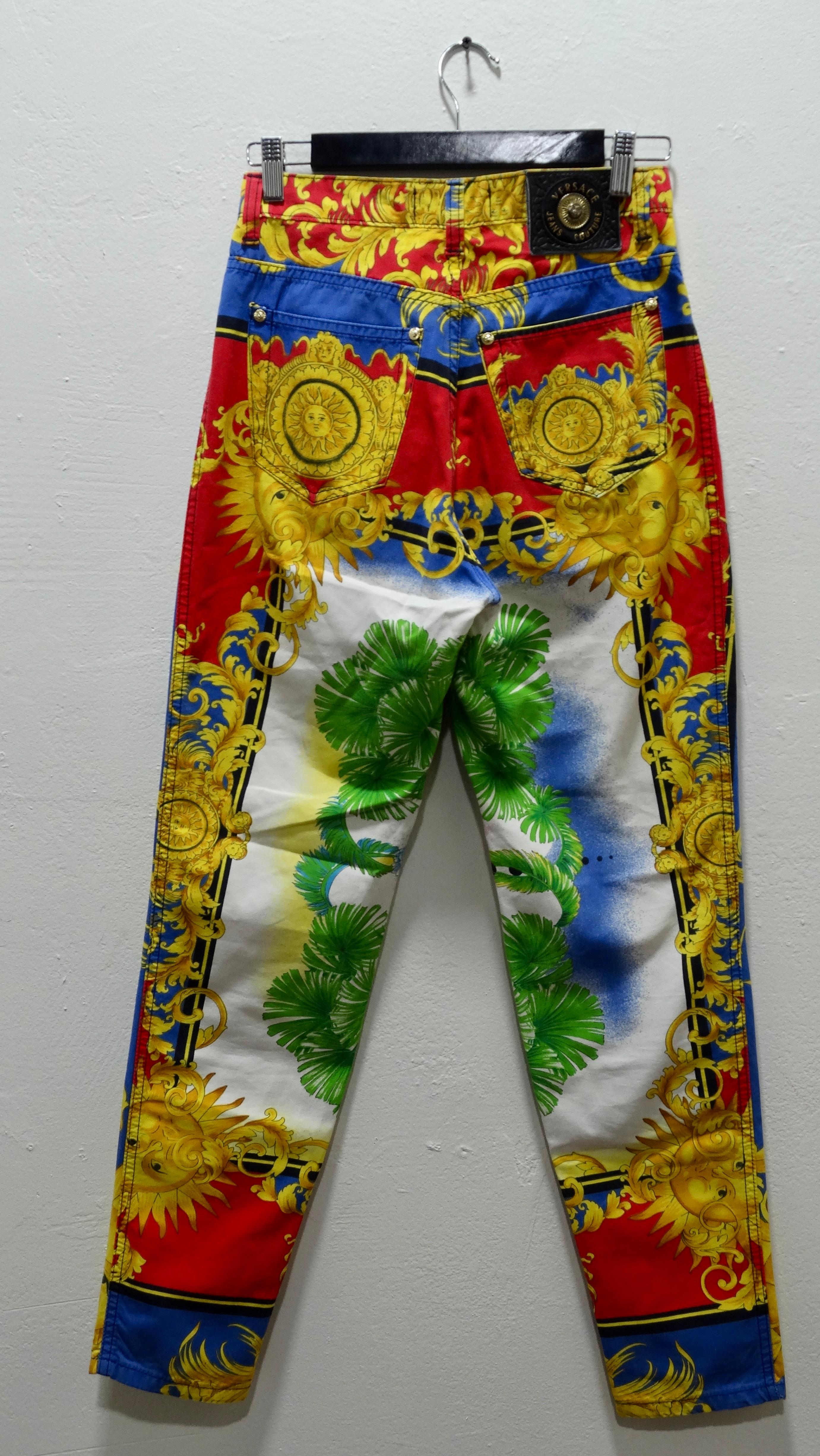 Beautiful Baroque!! Feel as bright as the sun in these stunning 1993 baroque sun print jeans from Gianni Versace Couture! These jeans feature stunning colors of red, blue, green and gold and beautiful celestial sun designs throughout. These jeans
