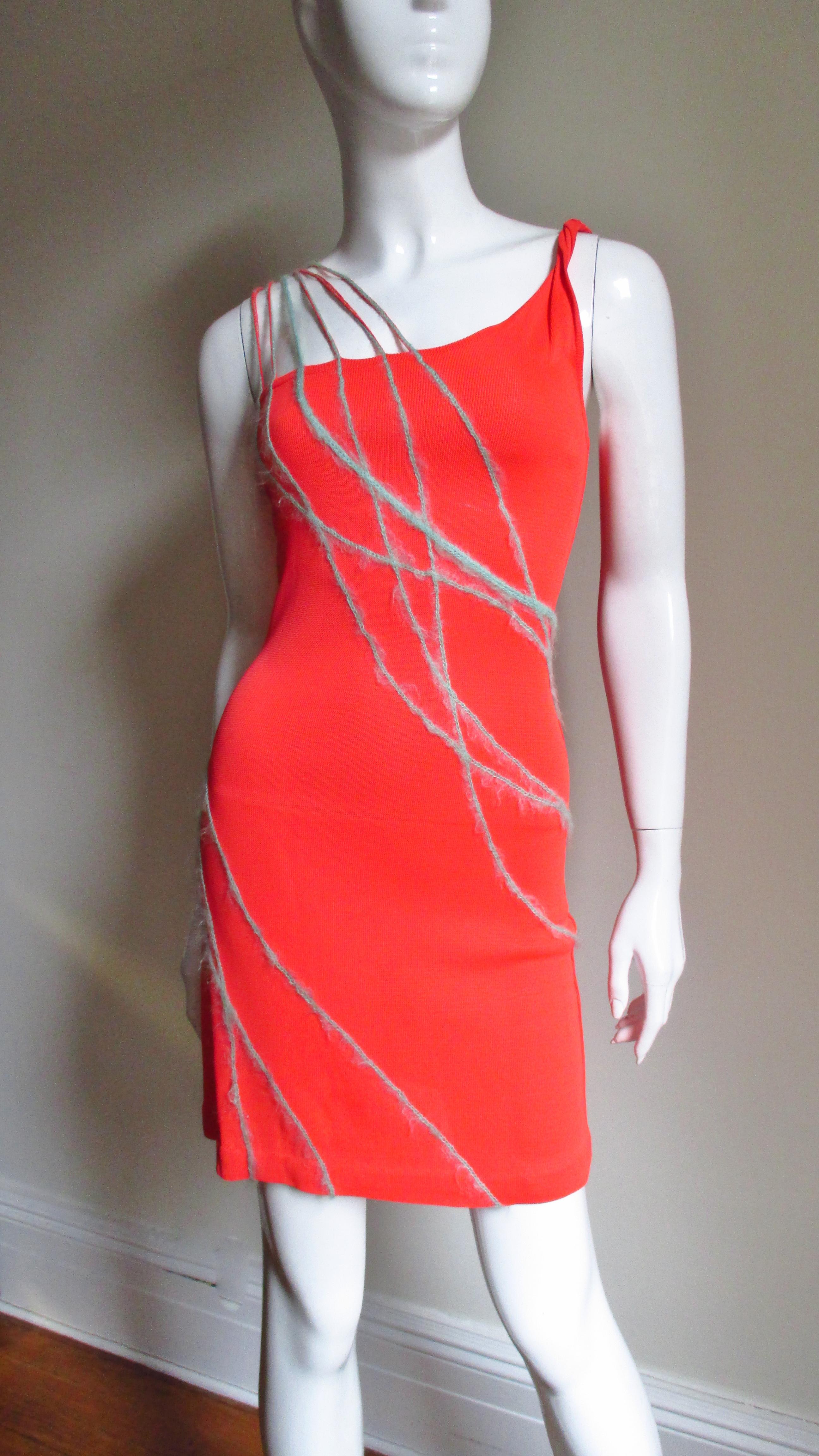 A fabulous orange one shoulder silk knit dress by Gianni Versace Couture.  The dress is highlighted with lines of light blue angora yarn over the one shoulder which extend down the front wrapping around at the dress.  It slips on over the head and