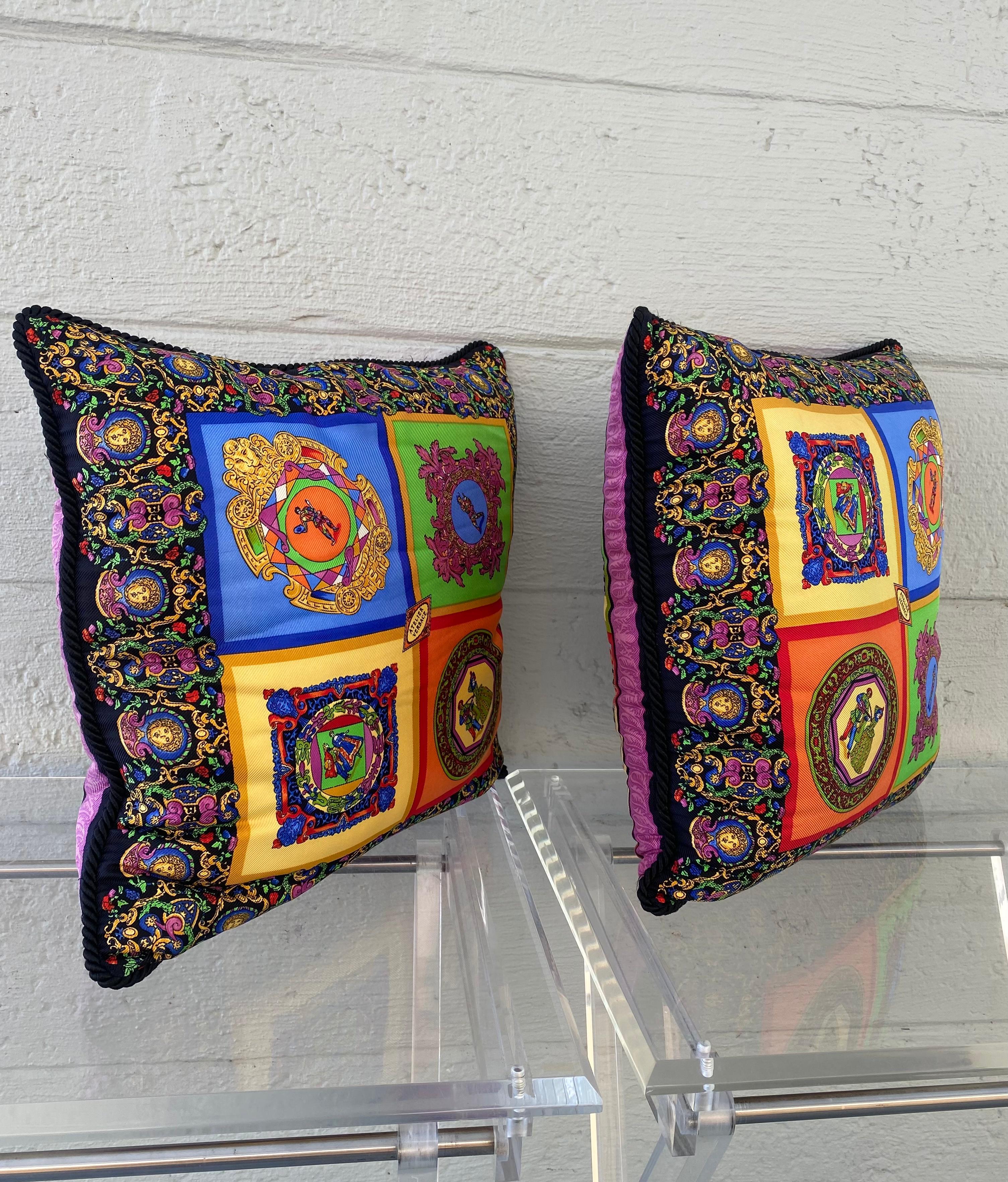 Iconic and timeless circa 1990's creation by Gianni Versace Atelier. Add high fashion to any space with these bright and vibrant pillows. Crafted from 100% silk and is embellished with the iconic Versace motifs. With its stunning variety of colours,