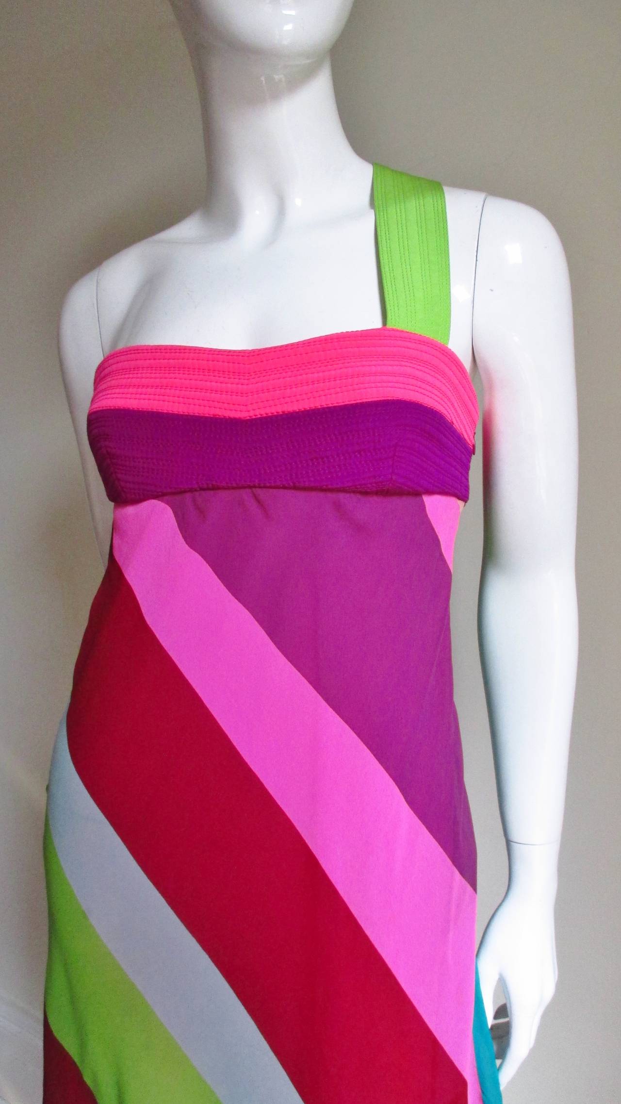 A pretty striped silk dress from Gianni Versace Couture in wide stripes of burgundy, green, bright pink, baby blue and turquoise.   There is a seam below the bust and an angled green strap at one shoulder crossing to the opposite side in the back. 