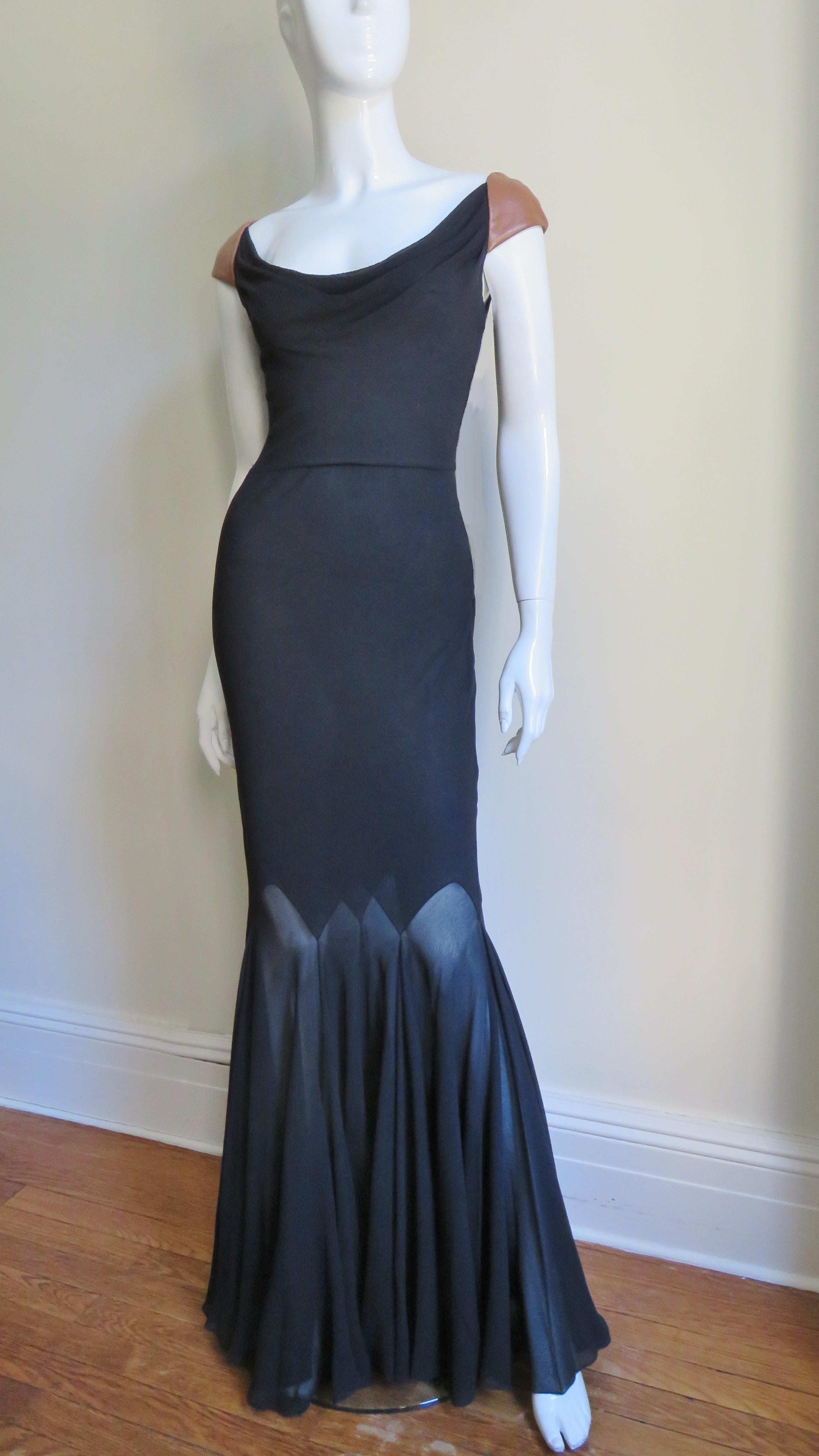 A gorgeous full length black silk gown from Gianni Versace Couture.  It has a front scoop neck, a deep cut out back and fabulous tan leather shoulders.  It is semi fitted though the thighs then flares via pointed seamed panels around the dress'