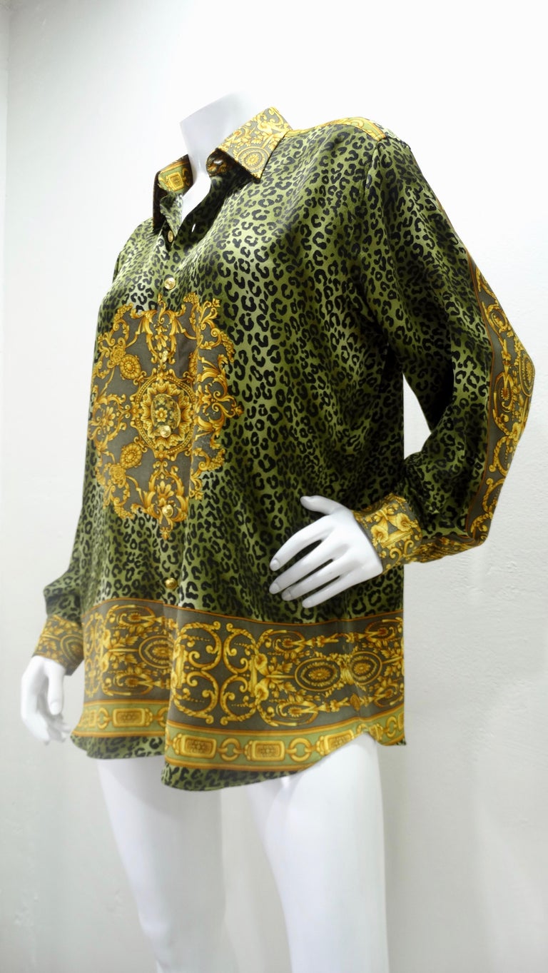 Snag yourself a piece from the Versace archives! Circa 1990s, this Silk long sleeve blouse is a two tone green color and features an allover leopard print mixed with Versace's signature Baroque pattern and gold toned buttons embossed with the