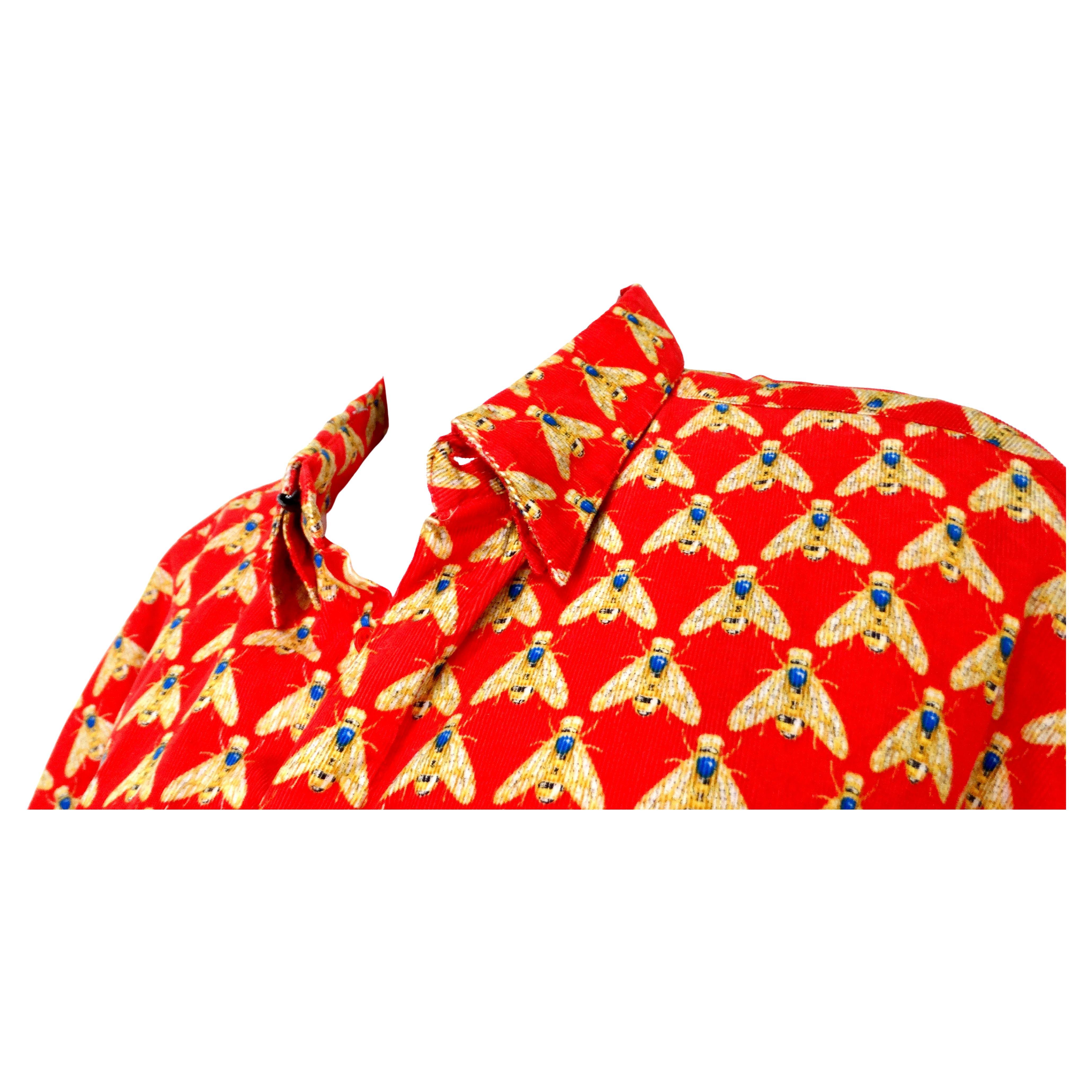 This iconic Gianni Versace Bee Print Corduroy Button-Up Long-Sleeve Shirt from the circa 1990s is a striking piece that exemplifies the designer's bold aesthetic and luxurious craftsmanship. Crafted from vibrant red 100% cotton corduroy, this shirt