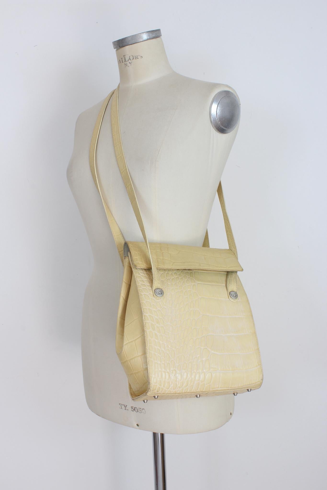 Gianni Versace vintage 90s beige bucket bag. Rigid shoulder bag in crocodile-print leather, medusa logo on the shoulder straps. Clip closure, internal pocket, lined with monogram print. Made in italy.

Height: 28 cm
Width: 20 cm
Depth: 6 cm
Shoulder