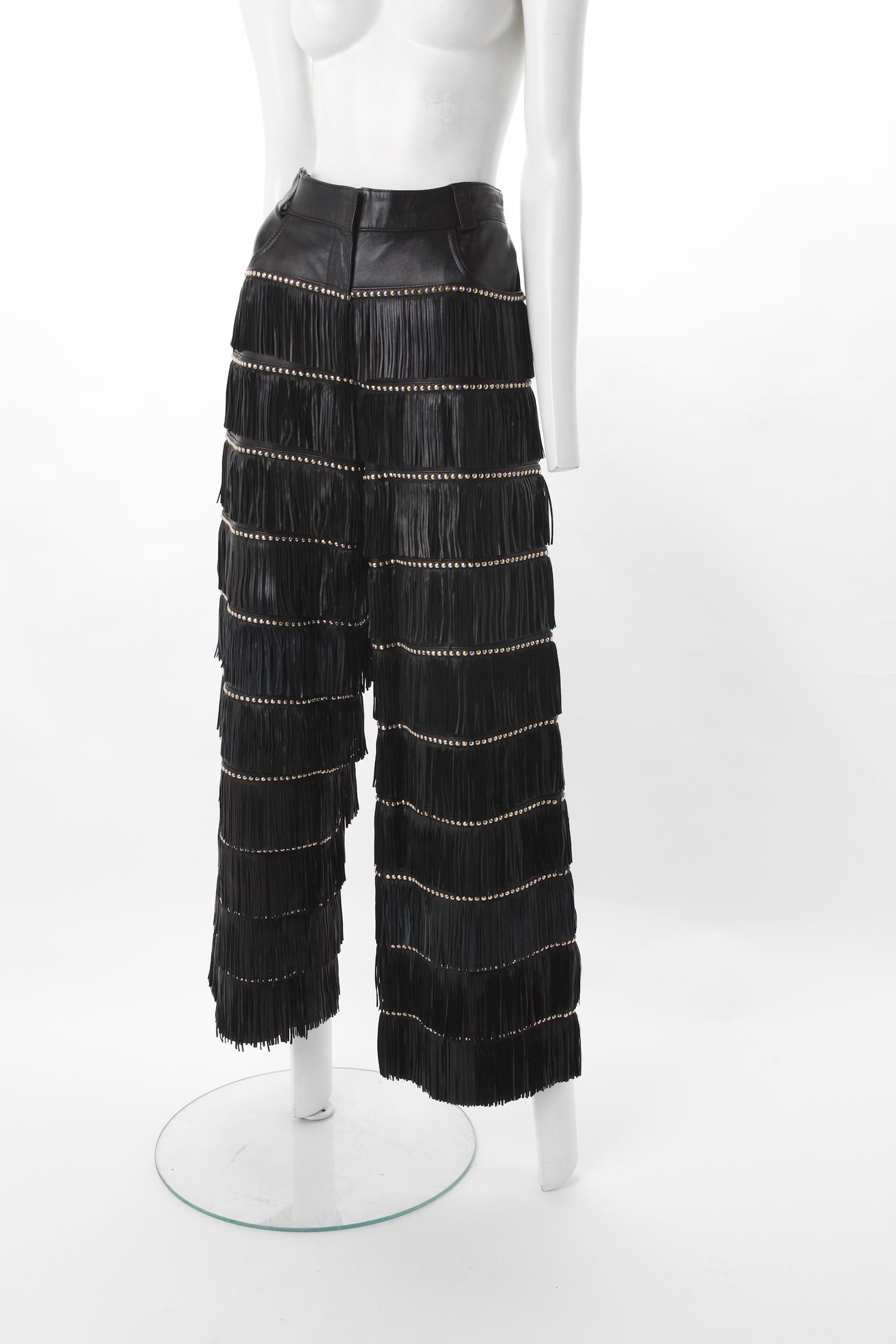 Gianni Versace Fringe Leather Pants,  F/W 1992.
Documented Gianni Versace black leather fringe pants with studded accents. Fall/Winter 1992 
Front slant pockets and Zip front with hook and eye closure.
Features silver and gold tone hardware.
Size