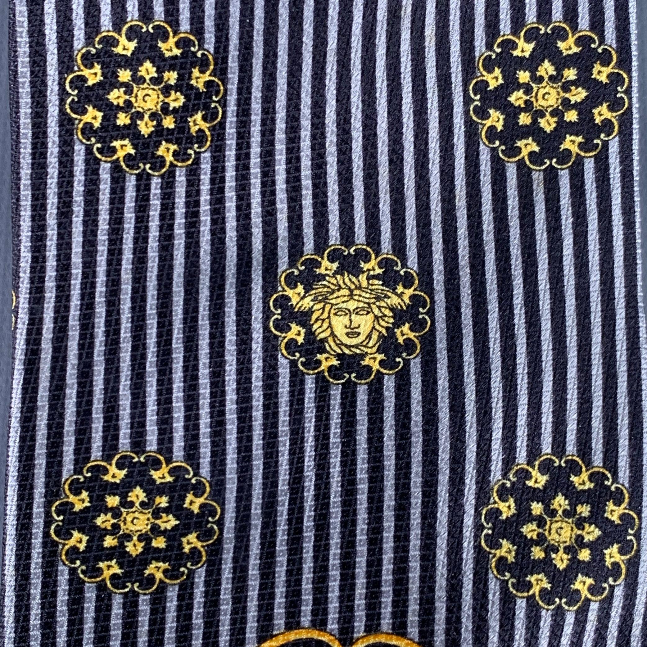 Vintage GIANNI VERSACE necktie
in a black and grey silk featuring gold tone Medusa heads on a stripe background, and baroque details. Made in Italy.Very Good Pre-Owned Condition.Width: 3.75 inches Length: 58 inches 
  
  
 
Sui Generis Reference: