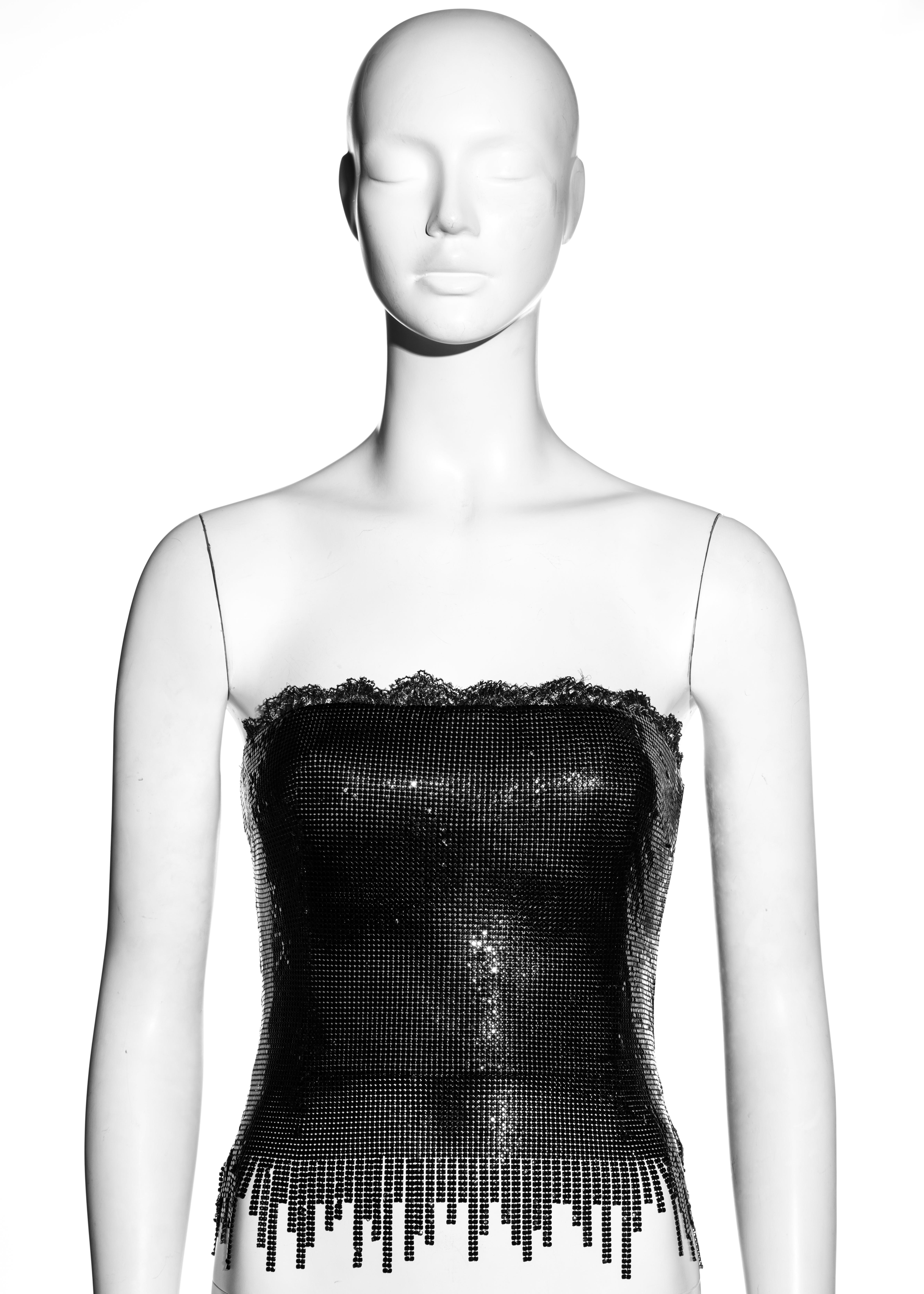 Gianni Versace - Corset de soirée en cotte de mailles en métal Oroton noir
96% métal, 4% soie
▪ Garniture en dentelle 
▪ Ourlet frangé 
▪ Corset intégré 
IT 40 - FR 36 - UK 8 - US 4
▪ Automne-Hiver 1999