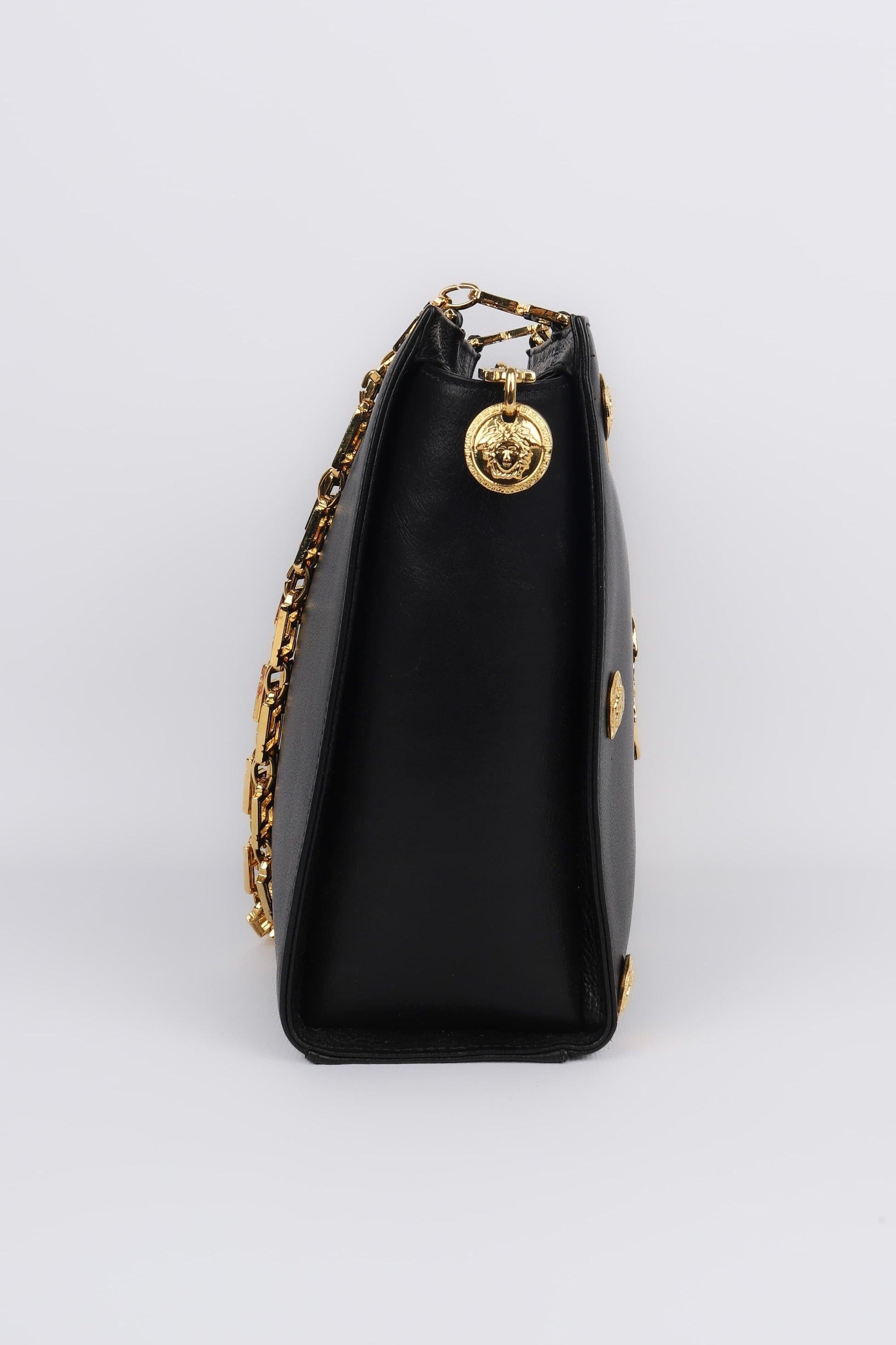 Versace -  (Made in Italy) Black leather bag with golden metal elements.

Additional information:
Condition: Very good condition
Dimensions: Length: 27 cm - Height: 22 cm - Depth: 7 cm - Handle: 97 cm

Seller Reference: S188
