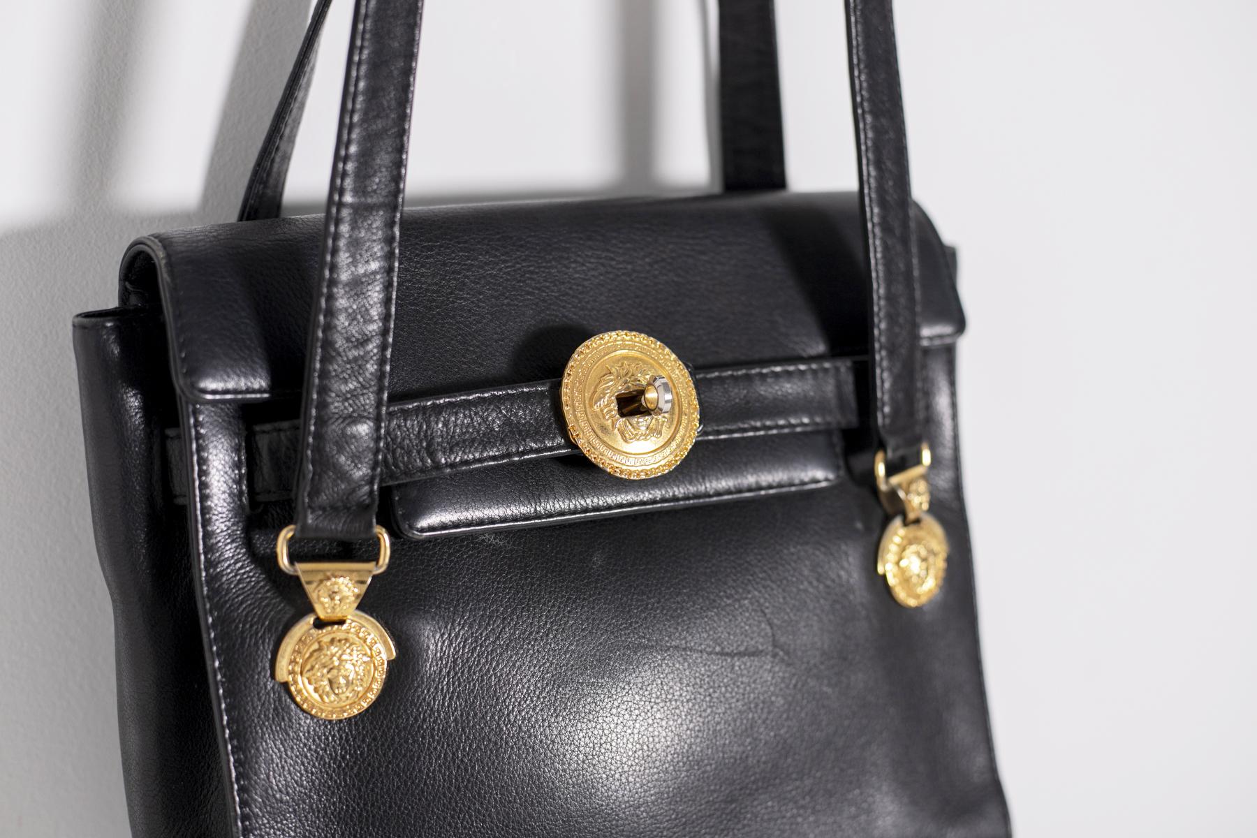 Wonderful Gianni Versace shoulder bag in black leather and golden metal inserts with iconic logo of the goddess Medusa of the famous 