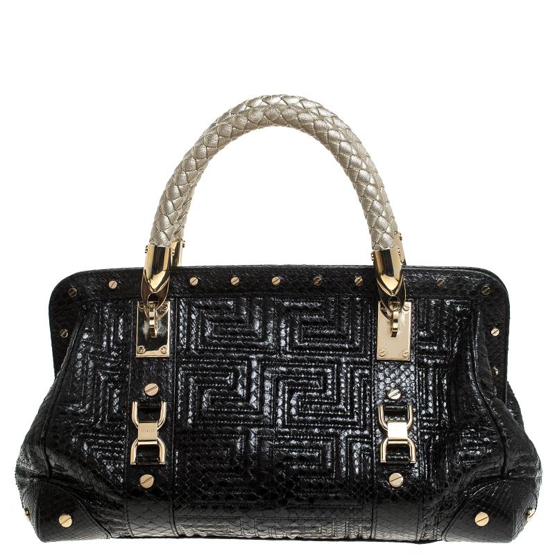 How gorgeous is this satchel from Versace! It carries an outstanding design and a fabulous interplay of leather and gold-tone hardware. It has a top leading to a satin interior while being held by two top handles. The shape and the brand logo on the