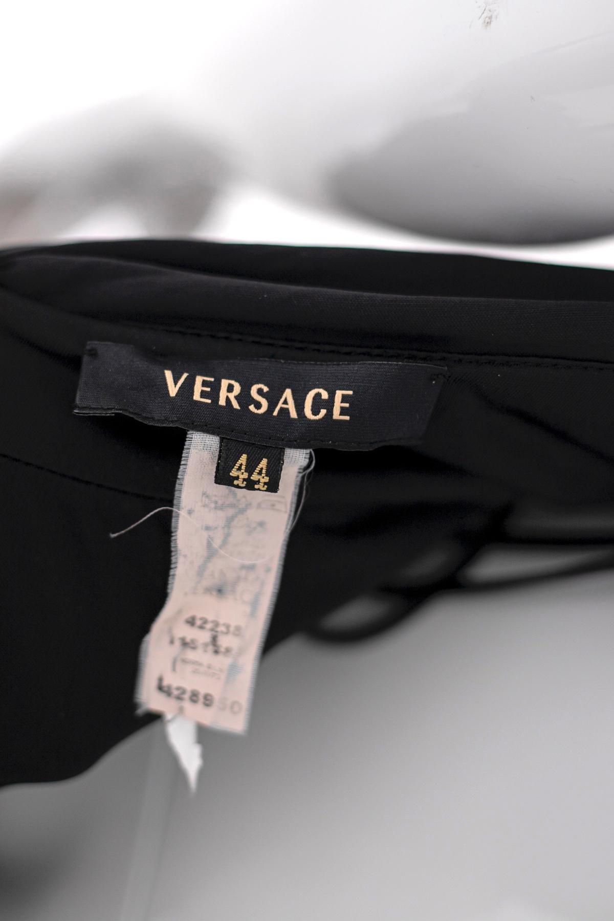 Magnifique robe de soirée courte noire, du célèbre designer Gianni Versace des années 1990, en Viscosa 100% très doux.
La robe a un dos ouvert et un décolleté de style américain fait avec une sangle en métal doré, dans la partie finale, derrière le