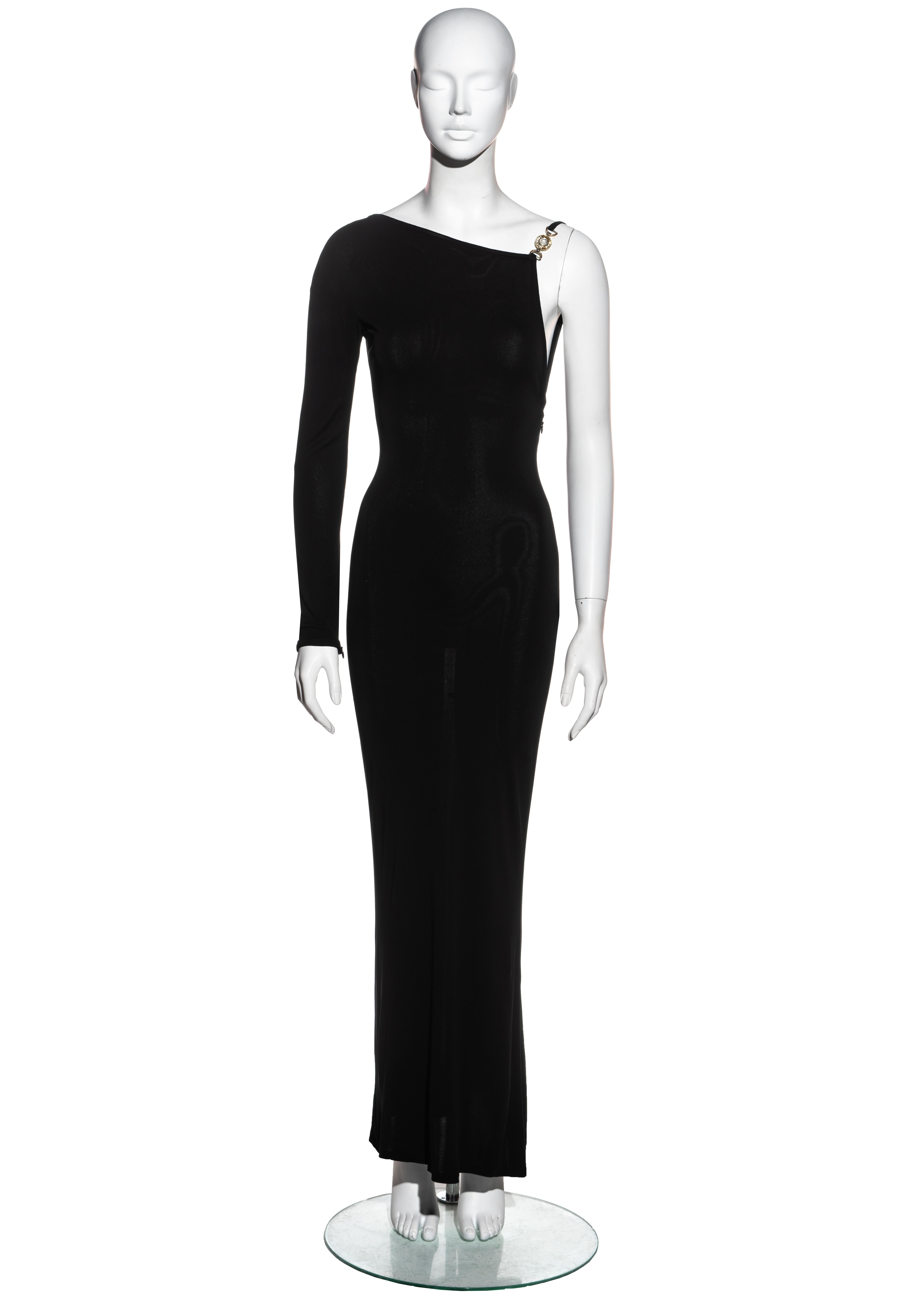 ▪ Gianni Versace black rayon jersey one-shoulder evening dress
▪ 2 gold-tone medusa coins adorned with crystals 
▪ Asymmetric neckline 
▪ Boning on bodice 
▪ Concealed zip fastening 
▪ IT 42 - FR 38 - UK 10 - US 6
▪ Fall-Winter 1996