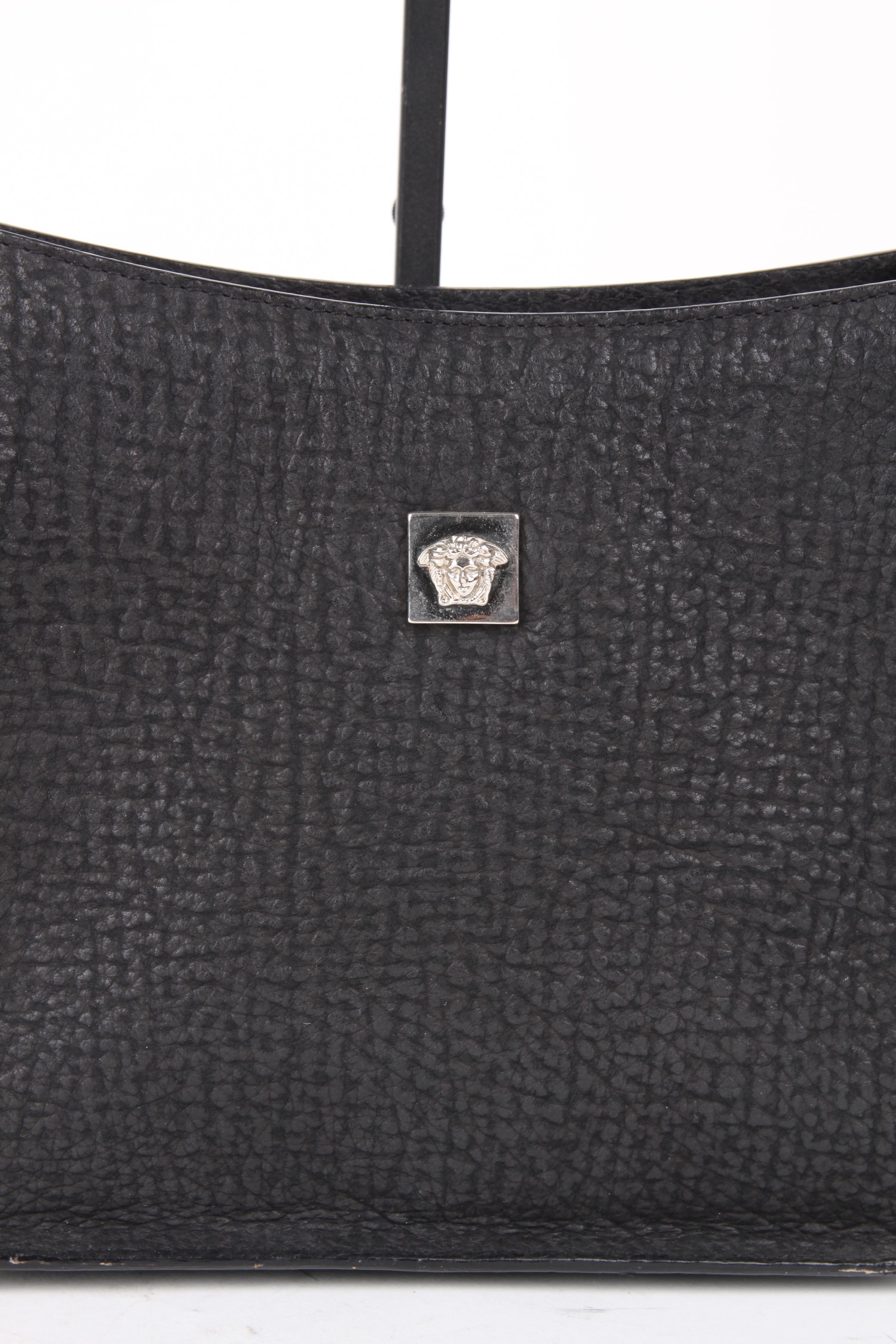 Gianni Versace Black Silver Leather Shoulder Bag.

This little bag makes a big statement. It features leather exterior with a matching black leather handle. The bag features a black suede lining, hook closure, one main compartment and one side