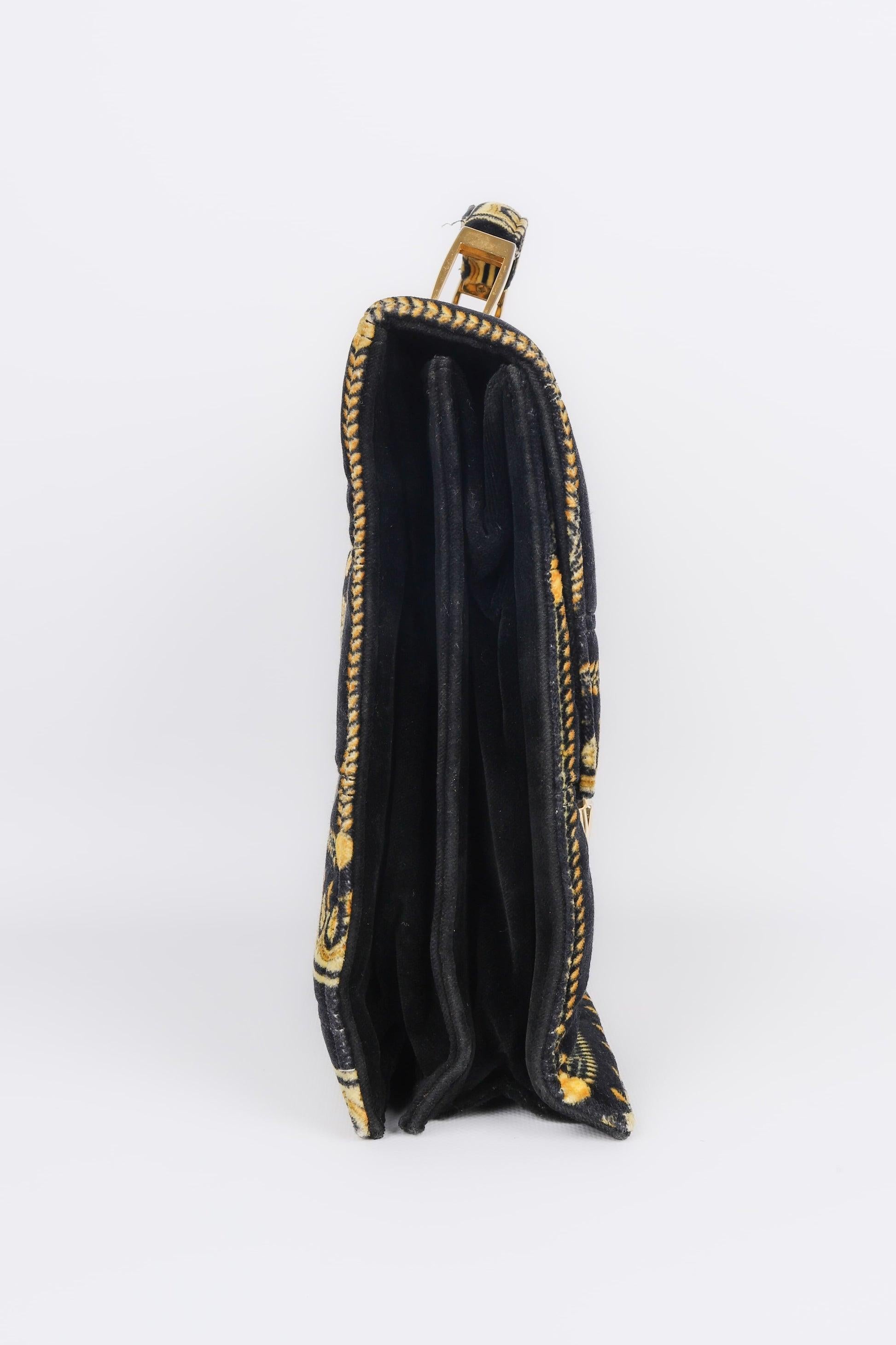 Versace - (Made in Italy) Black velvet bag with golden patterns and golden metal elements.

Additional information:
Condition: Good condition
Dimensions: Length: 33 cm - Height: 27 cm - Depth: 12 cm - Handle: 21 cm

Seller Reference: S189