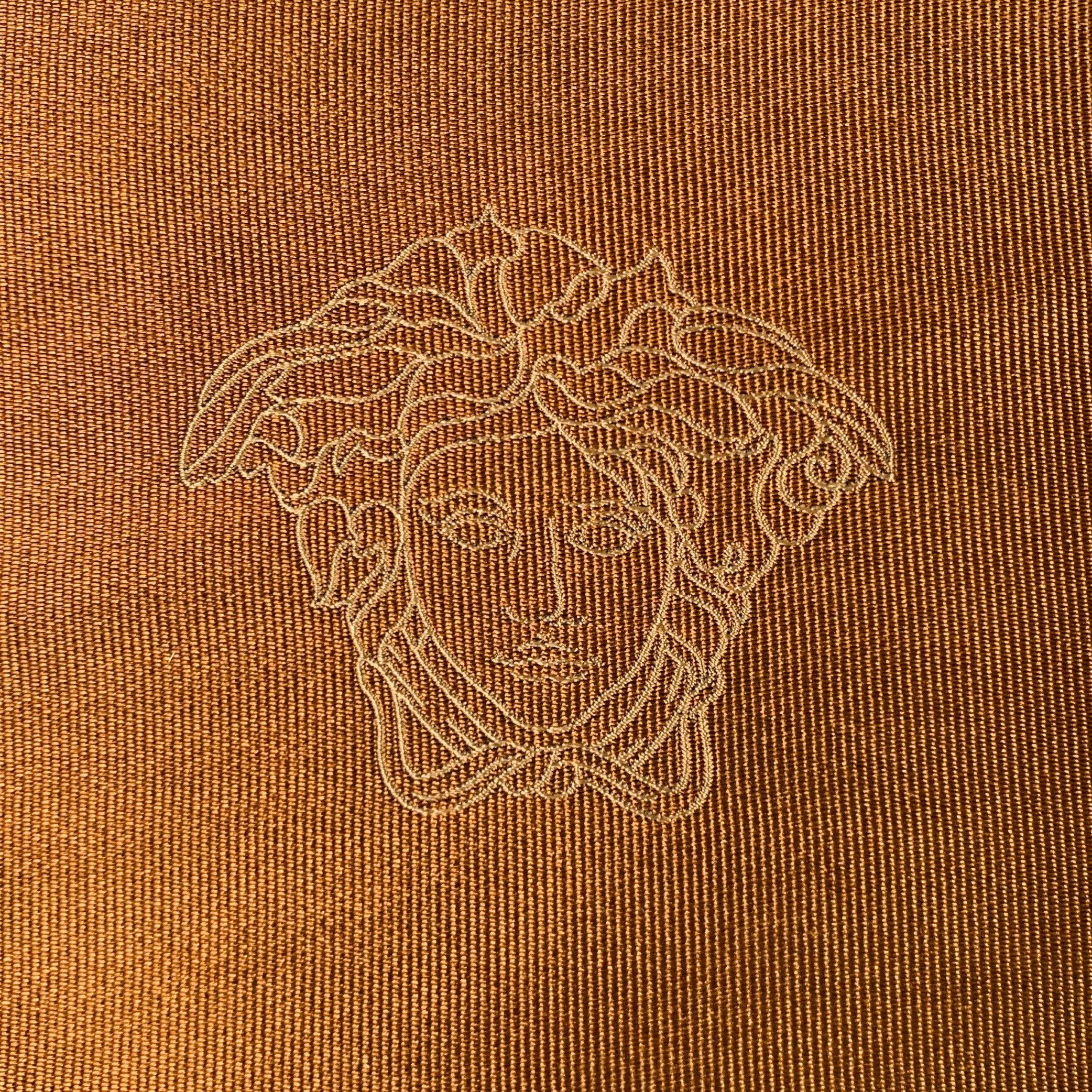 GIANNI
VERSACE pocket square in a brown and taupe silk jacquard featuring signature Medusa heads. Made in Italy.Very Good Pre-Owned Condition. Minor signs of wear. 

Measurements: 
  13 inches  x 13 inches  
  
  
 
Sui Generis Reference: