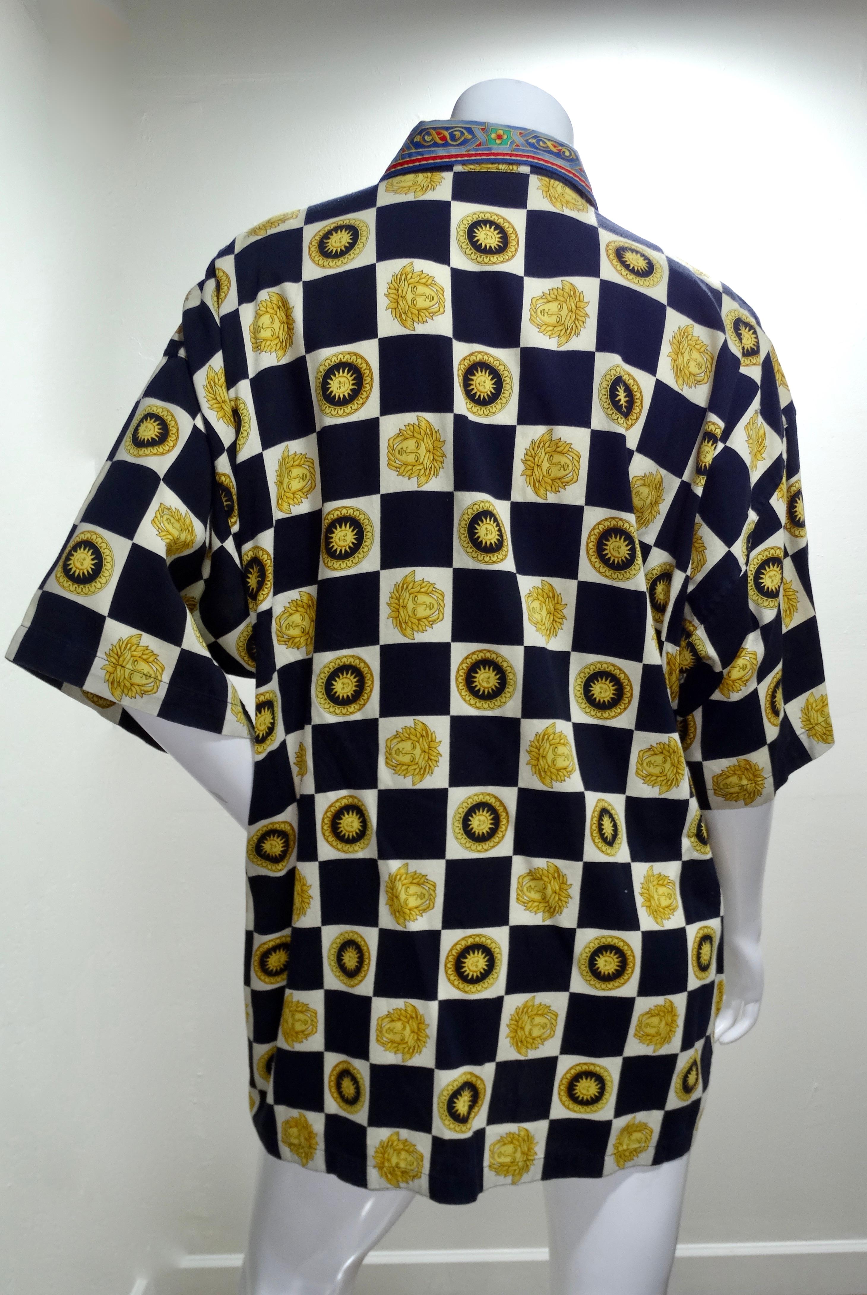 Snag yourself a piece from the Versace archives! Circa 1990s, this cotton shirt features a black and white checkered motif with the Medusa head, celestial suns and a stain glass design down the button up front and on the collar. Classic and