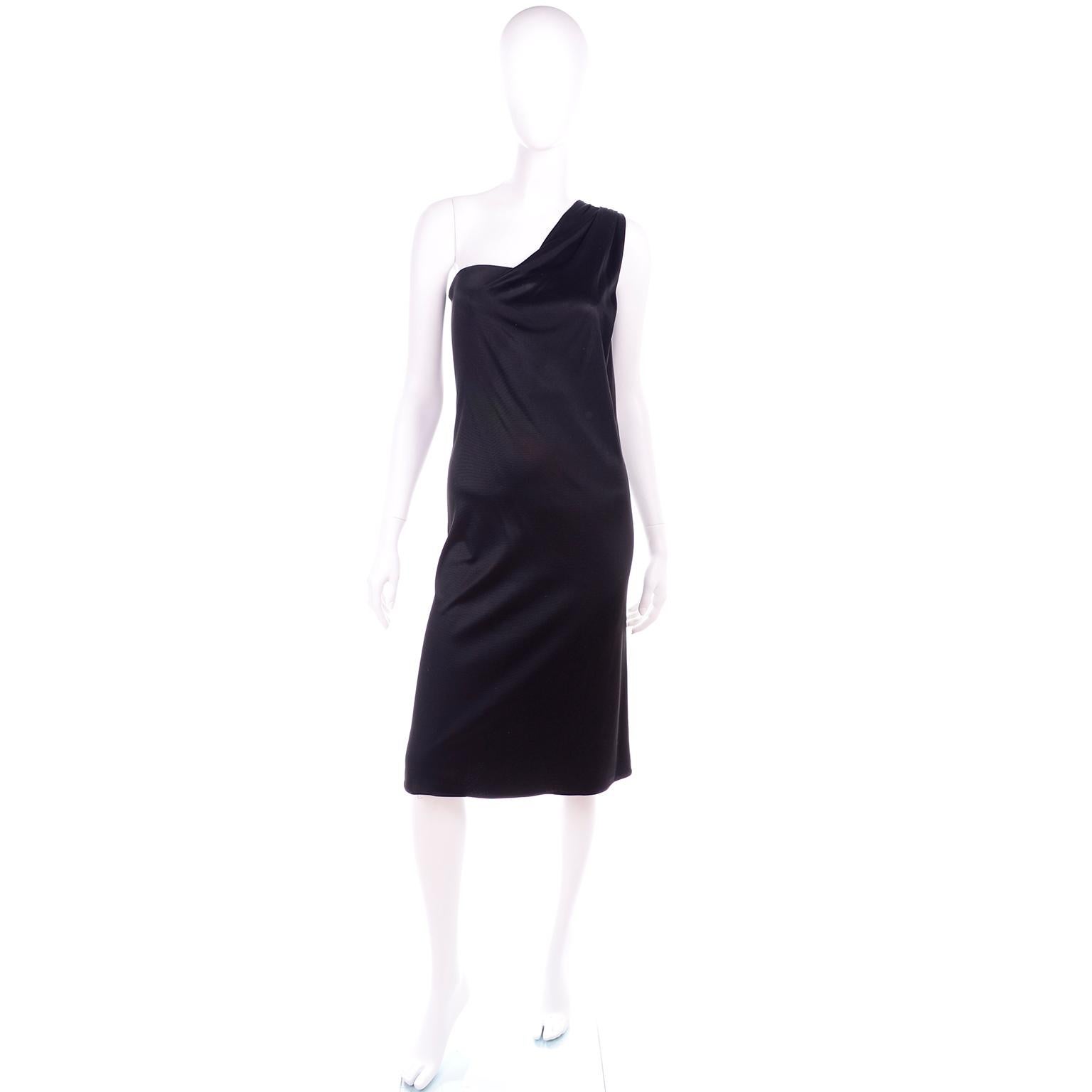 This is a fabulous little black dress from Versace's 1998 collection. This one shoulder 90's dress has a metal side zipper and a wire bustier insert. We love the leather and metal buckle in the back with the small medusa head. The dress is in a