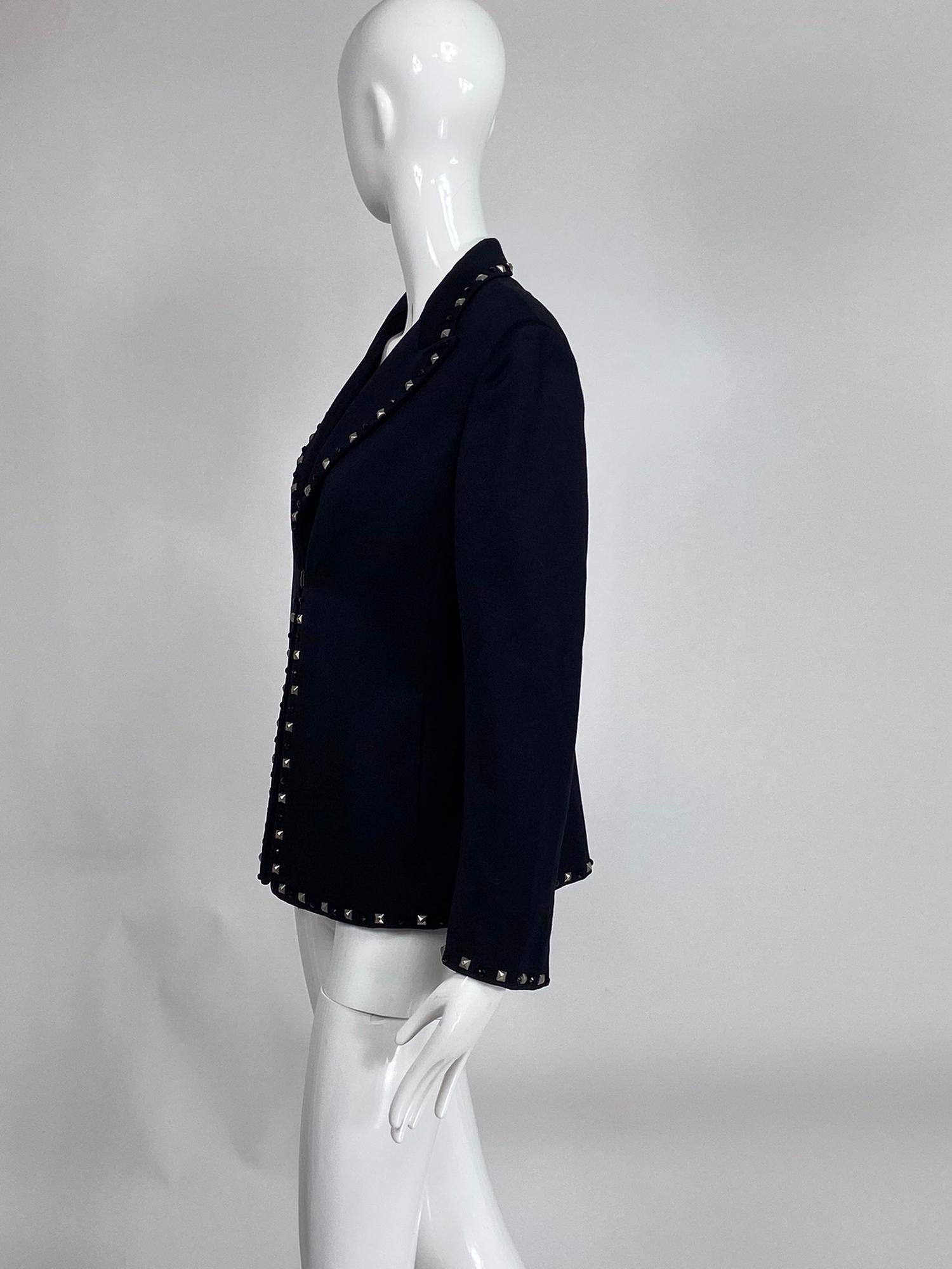 Gianni Versace Couture black wool bead & stud trimmed jacket. Single breasted jacket is trimmed in alternating black beads and square faceted silver studs, the jacket closes at the waist front with a single snap hook and eye. Notched lapel collar.