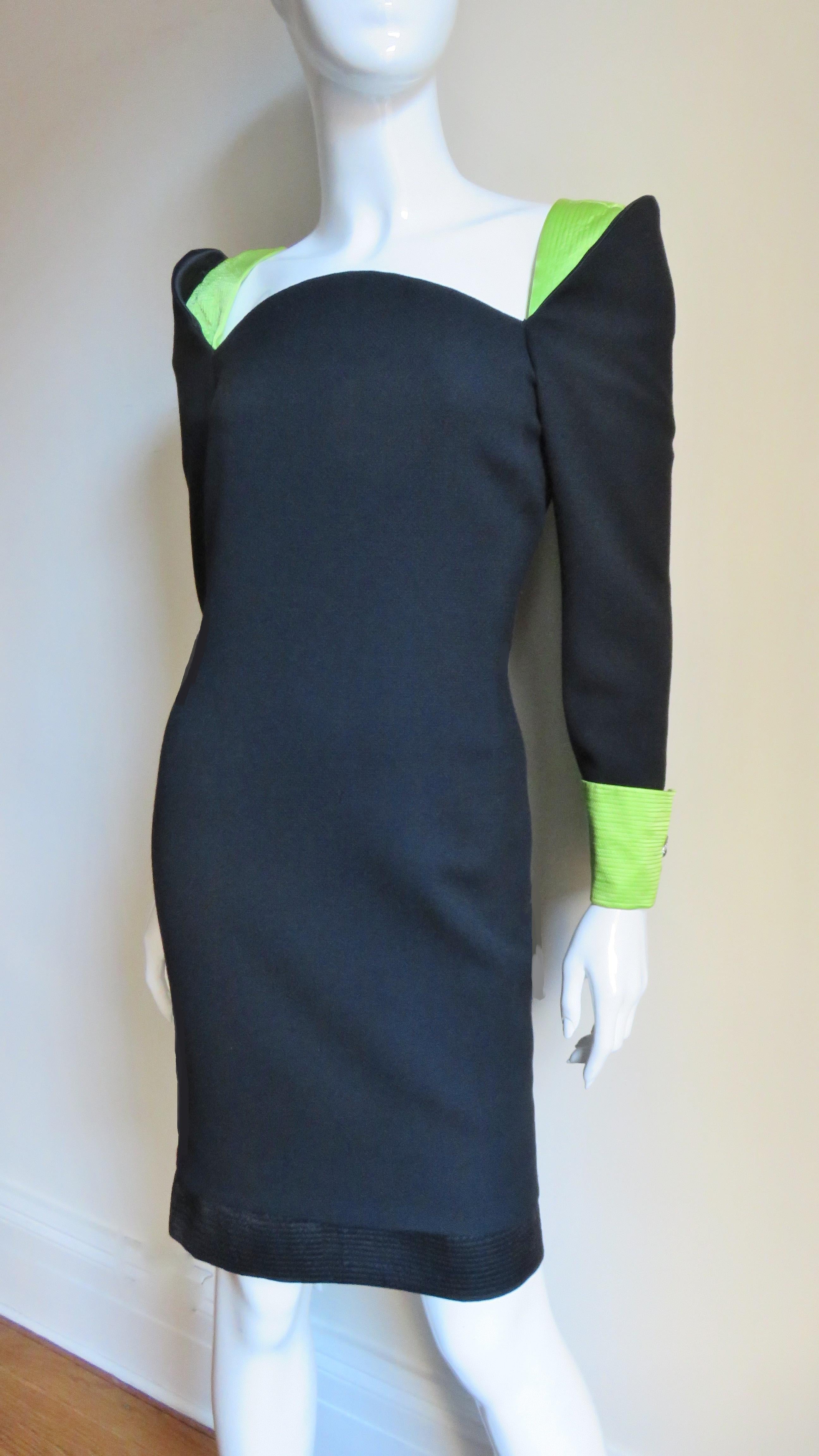 A fabulous dress from Gianni Versace Couture in black light weight wool and green silk.  It is semi fitted with fold back cuffs with elaborate cufflinks and inset shoulders all in bright green silk highlighted with rows of top stitching. The dress