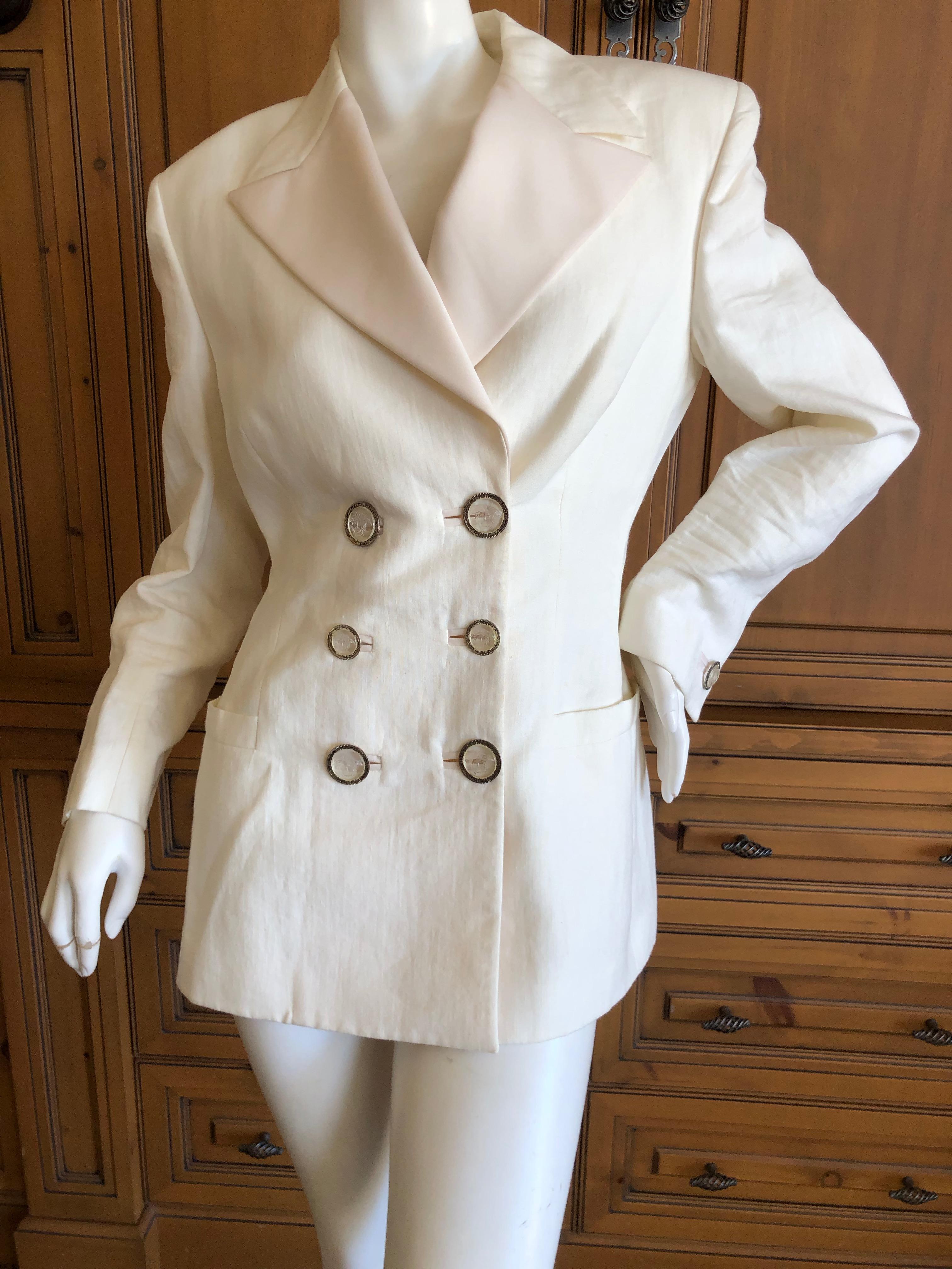 Gianni Versace Couture Fall 1992 Ivory Linen Tuxedo Suit with Corset Stay Details.
Ivory linen with silk satin lapels and stripes up the side of the shorts, this features tiny medusa headed ornaments that look like corset stays up the back.
Size