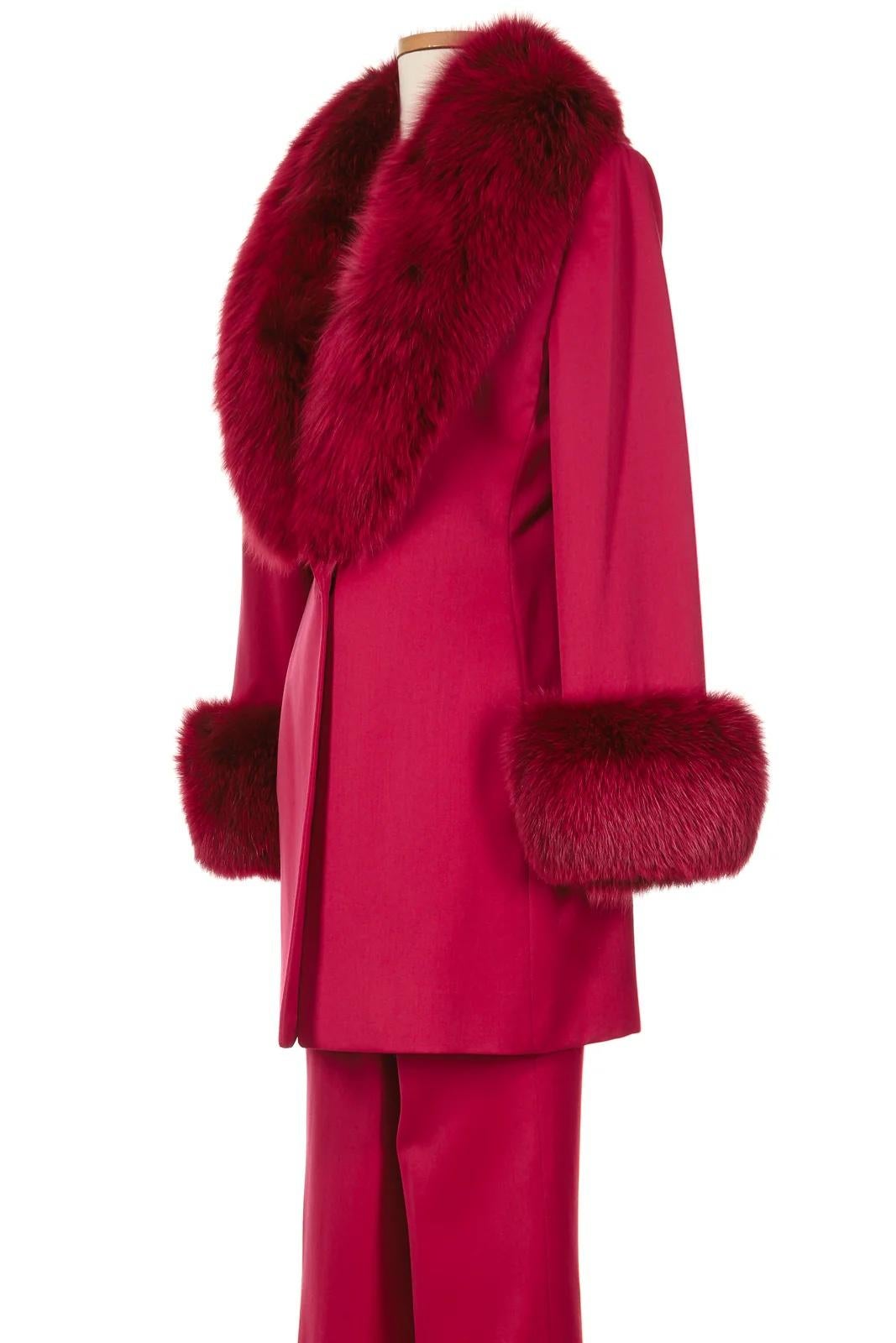 VINTAGE GRACE NY

A striking masterpiece from Gianni Versace by Donatella Versace's Fall 1998 collection, this tailored pant suit exudes pure glamour. Crafted in a bold, deep red hue, the structured jacket features an opulent fox fur collar and