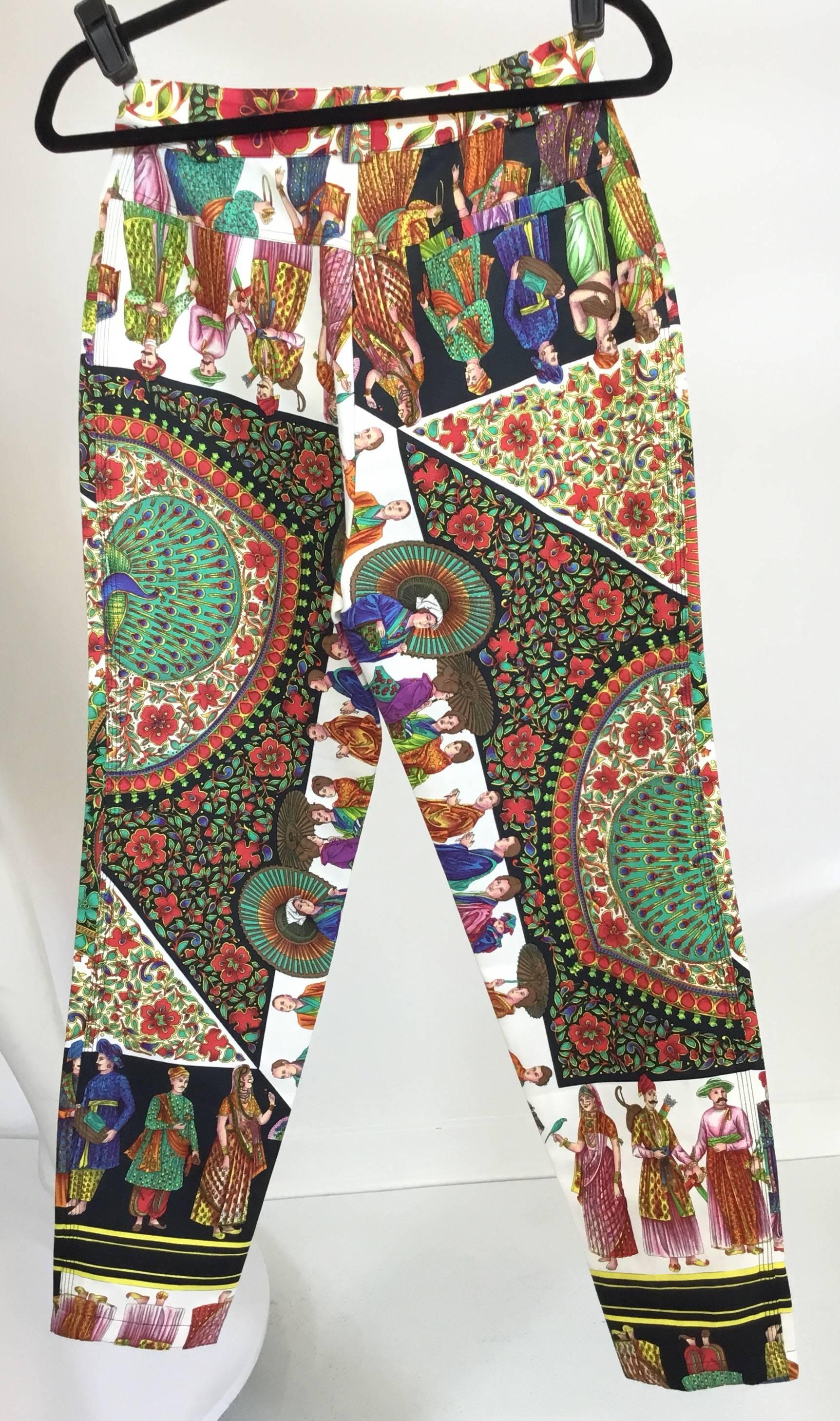 Vintage 1990's Gianni Versace pants features a vibrant, multi-colored print throughout with a gold-tone metal Medusa button closure and zipper fastening. Pants also have pockets at the waist and belt loops. 72% cotton and 28% silk. Label size IT42