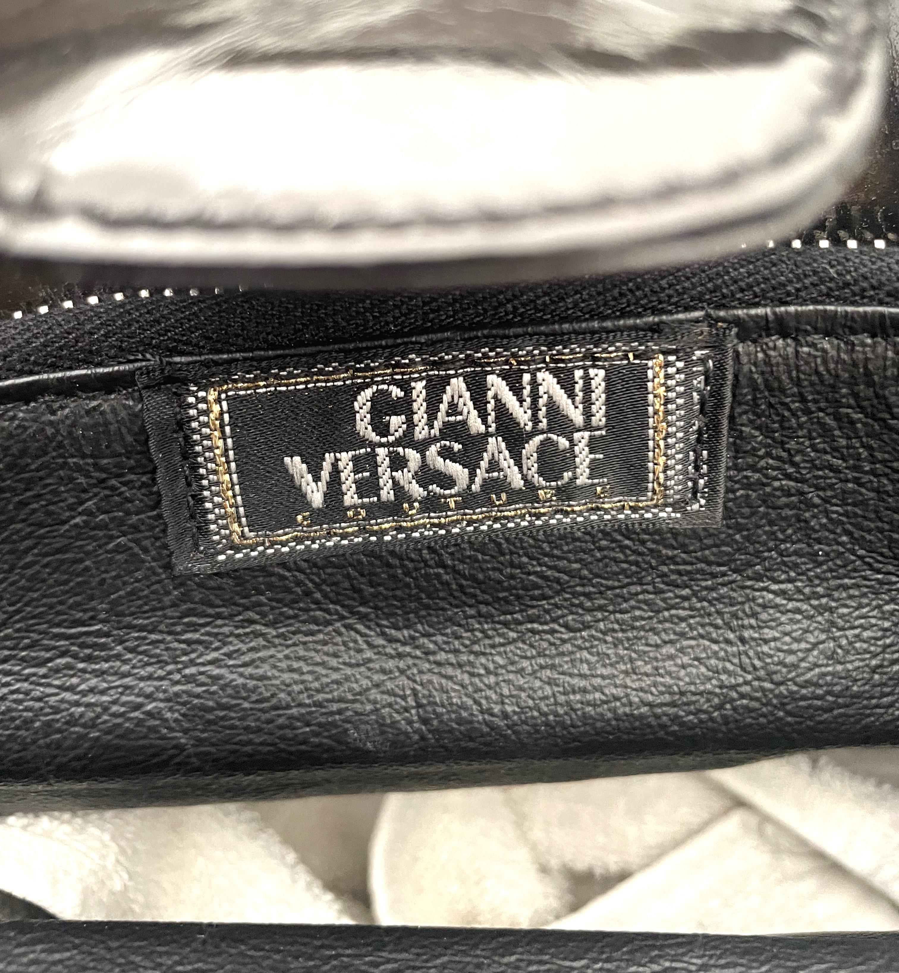 Este raro y excepcional bolso Gianni Versace Couture de piel negra brillante es una pieza única de la colección de los años 90. Representa una pieza por excelencia de la moda de lujo de un periodo en el que la marca estaba en su apogeo bajo la