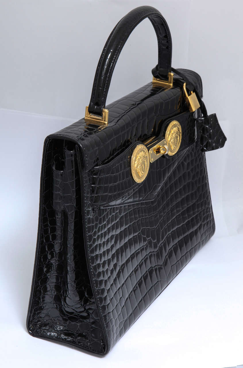 Extremely rare Gianni Versace Couture Croc embossed Kelly bag with iconic Medusas. Black and Gold. Princess Diana made this bag famous by wearing it to Gianni Versace’s funeral.

Height: 9, Width: 12, Depth: 4 inches