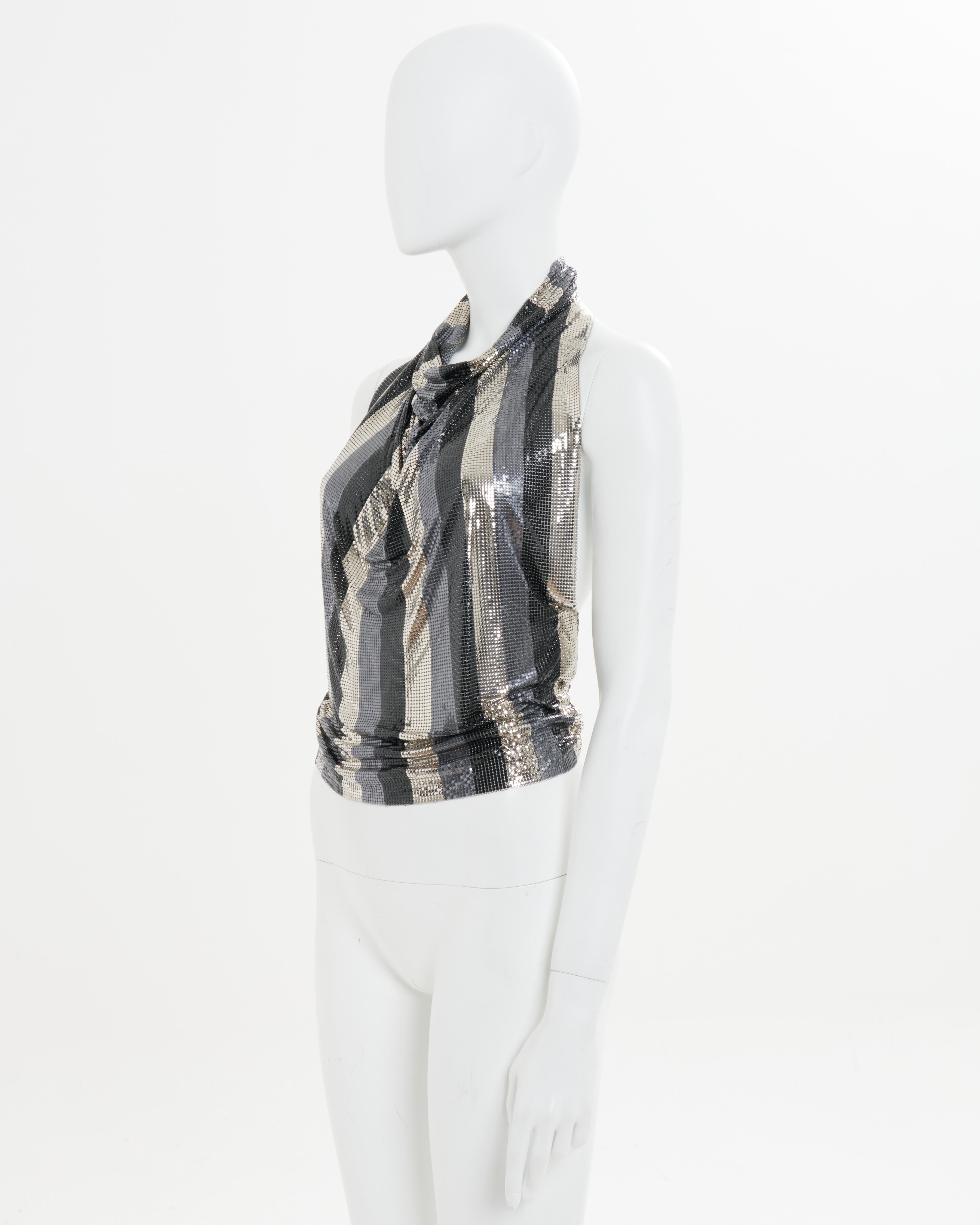 - Gianni Versace Oroton Halstuch aus dem Archiv
- Verkauft von Skof.Archive 
- Herbst - Winter 1983
- Schwarzes, goldenes und brüniertes silbernes Kettenhemd mit Streifen
- Offener Rücken 
- Amerikanischer Ausschnitt
- Halsausschnitt, der schön