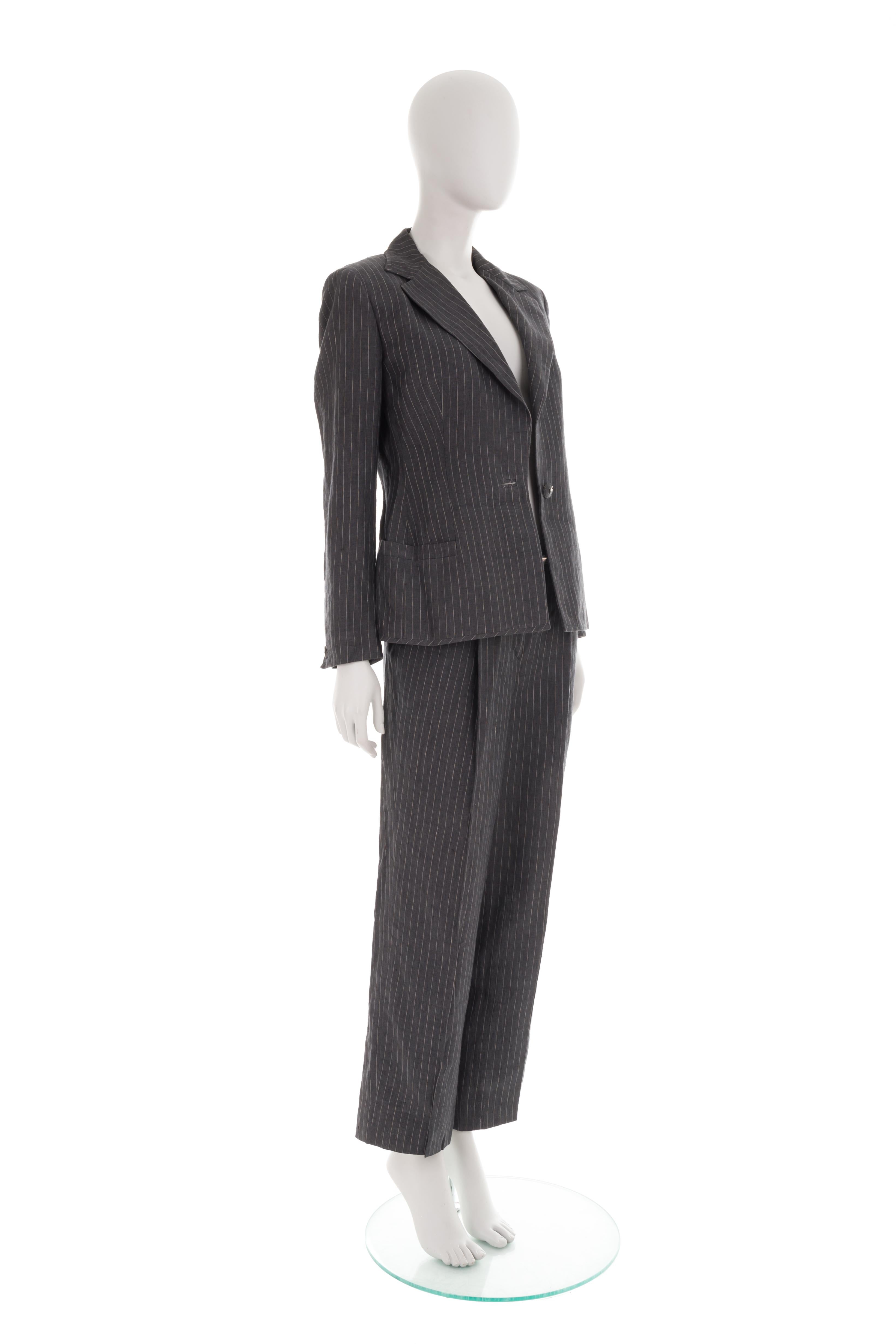 - Versace by Donatella Versace 
- Sold by Gold Palms Vintage 
- Dark grey striped linen suit
- Large lapel padded jacket
- Front logo button
- Relaxed suit trousers
- Additional mini belt with logo 
- Size: IT 44