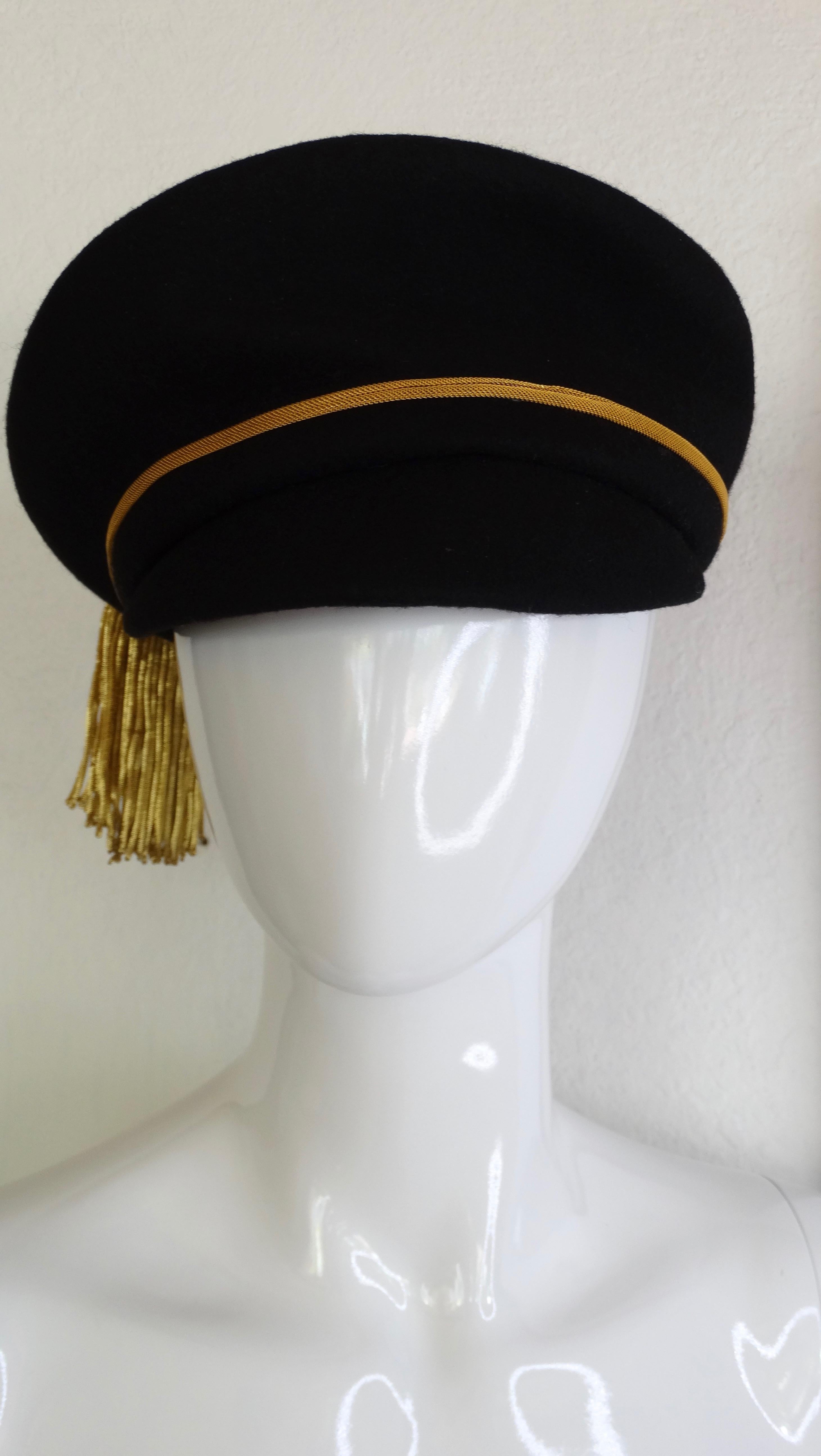 Complete your hat collection with this extremely rare Versace hat! Circa 1990s, this black felt train conductor style hat features a gold trim and large gold threaded tassel which hangs from a 24K Medusa embossed medallion framed with black