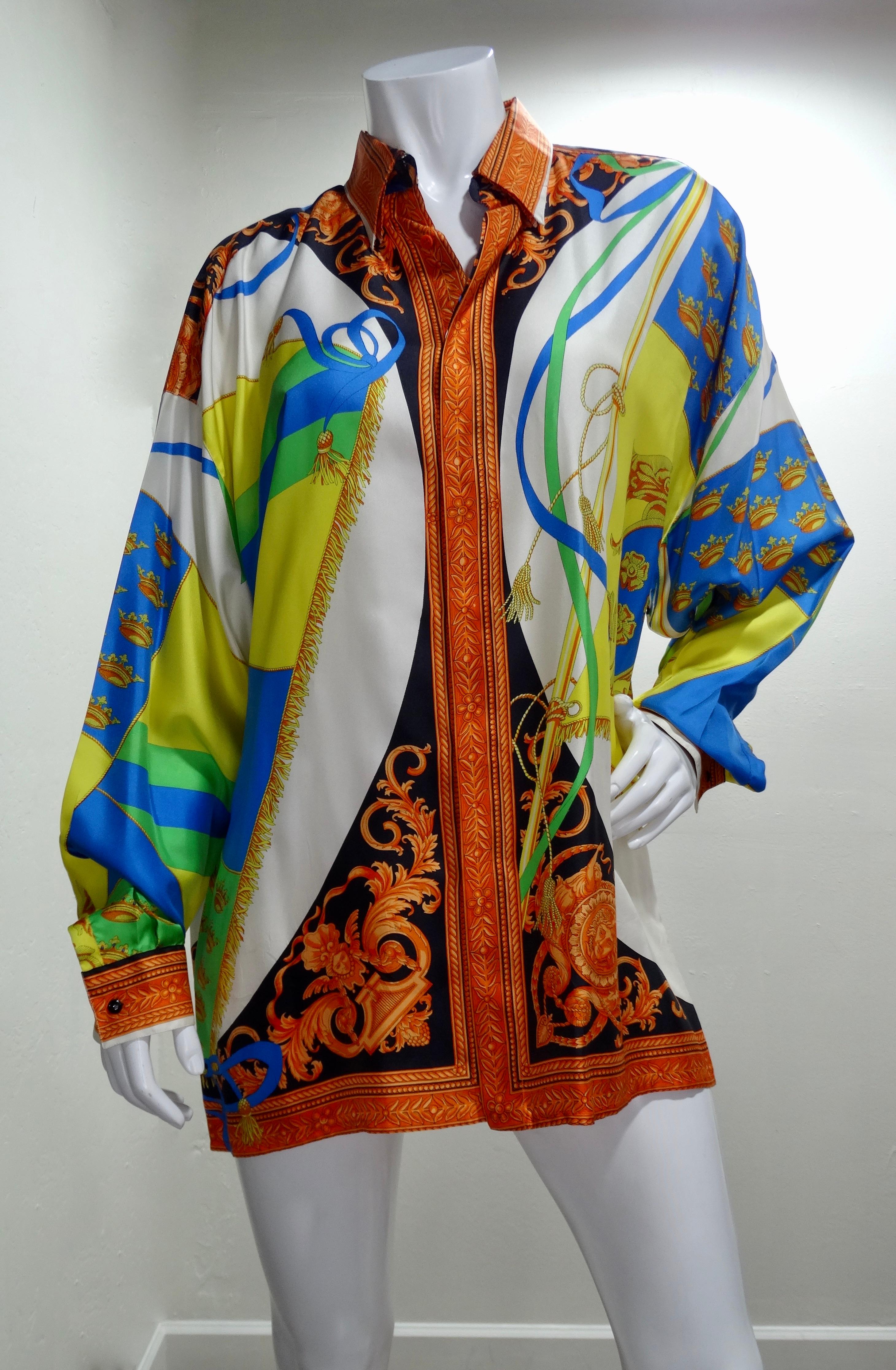 Snag yourself a piece from the Versace archives! Circa 1990s, this colorful silk shirt features a motif of gold fringe flags with signature Versace symbols like the Medusa head and Baroque designs. Classic and timeless, this coveted piece will pair