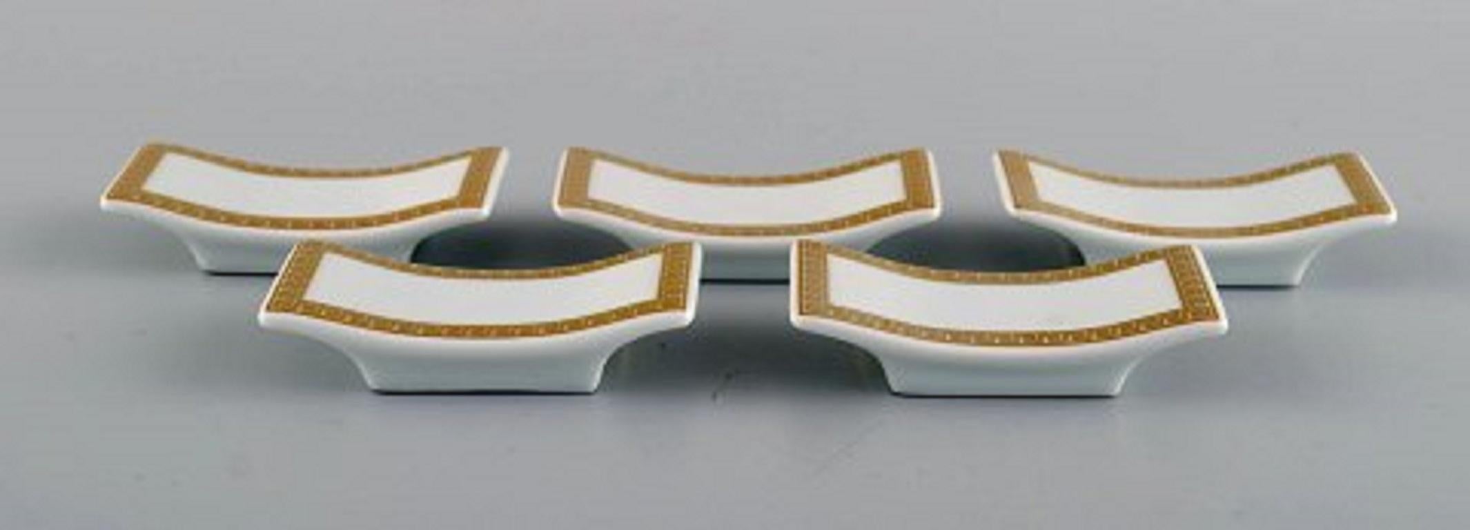 Gianni Versace for Rosenthal. Five knife rests in white porcelain with gold ornamentation, late 20th century.
Measures: 7.5 x 2 cm.
In perfect condition.
Stamped.
 