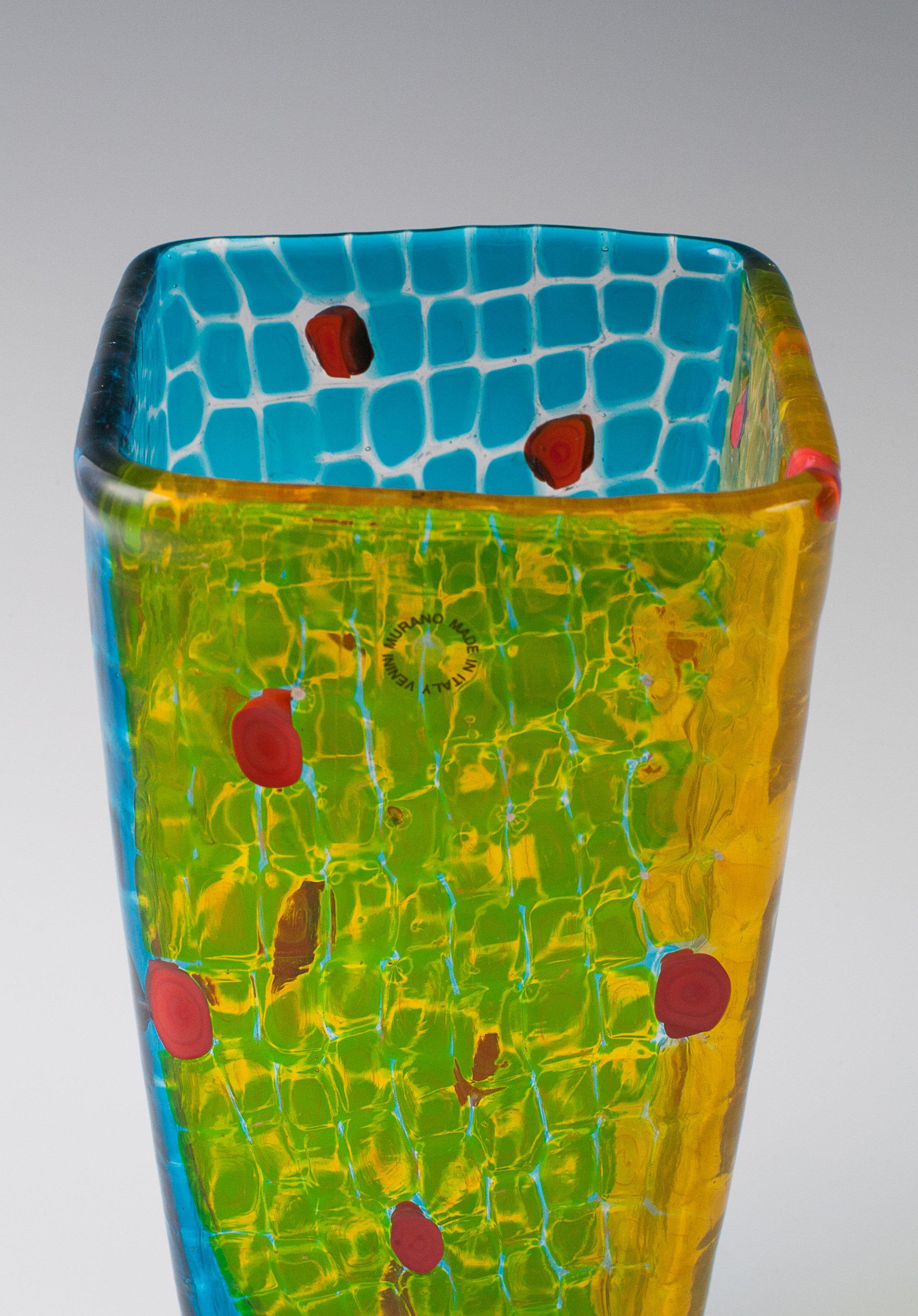 Gianni Versace vase, for Venini, 1998.
1st production.
Large square form in blue and yellow transparent glass with opaque red inclusions, engraved signature “venini Gianni Versace 1998/113”.
Original label Venini Murano, made in Italy.
Includes