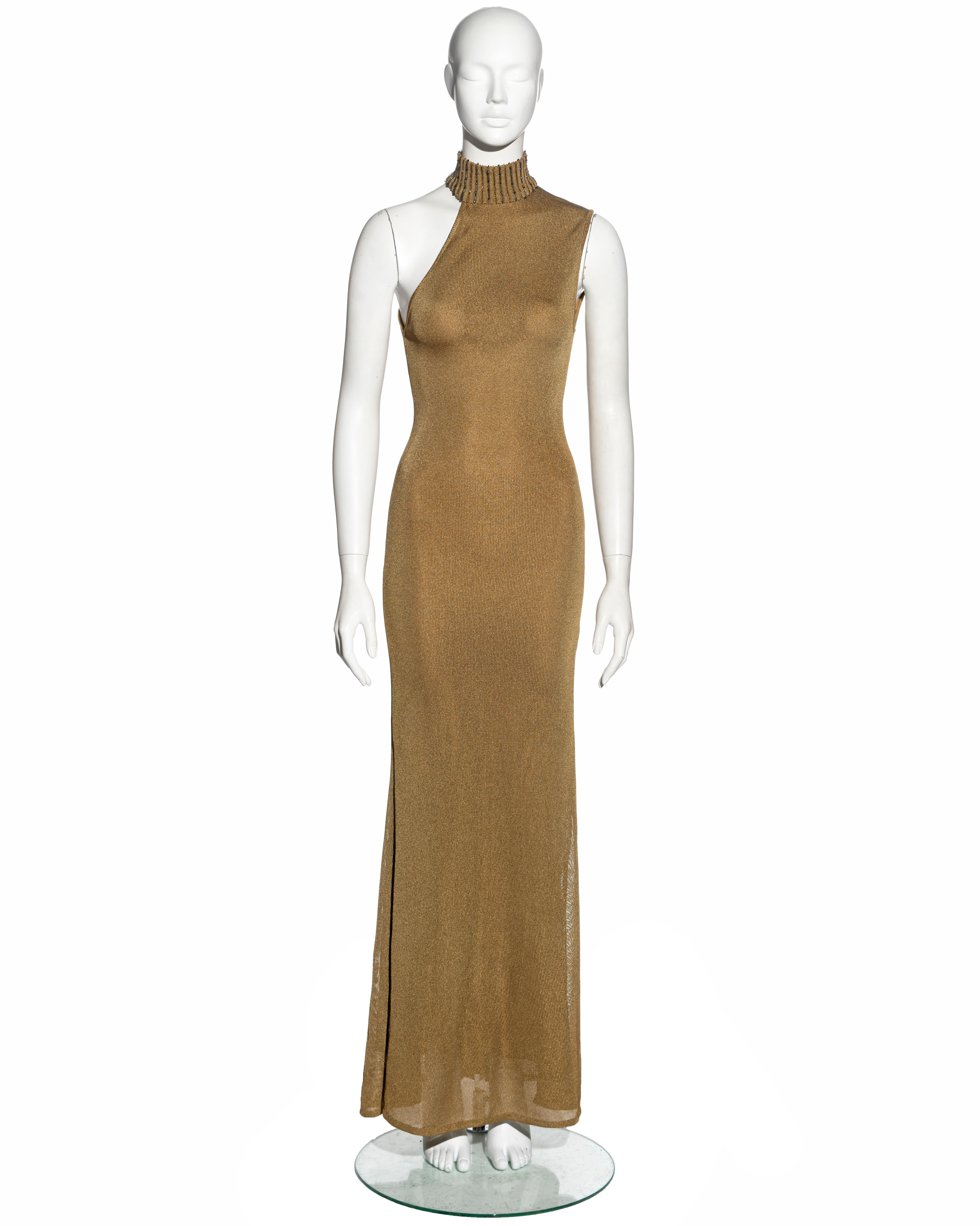 ▪ Gianni Versace evening dress
▪ Constructed from gold knitted rayon
▪ Turtleneck with embellished with vertical rows of bugle beads
▪ Asymmetric neckline
▪ Floor-length skirt 
▪ Lined
▪ Fall-Winter 1996
▪ Size 38
▪ Made in Italy  

All photographs