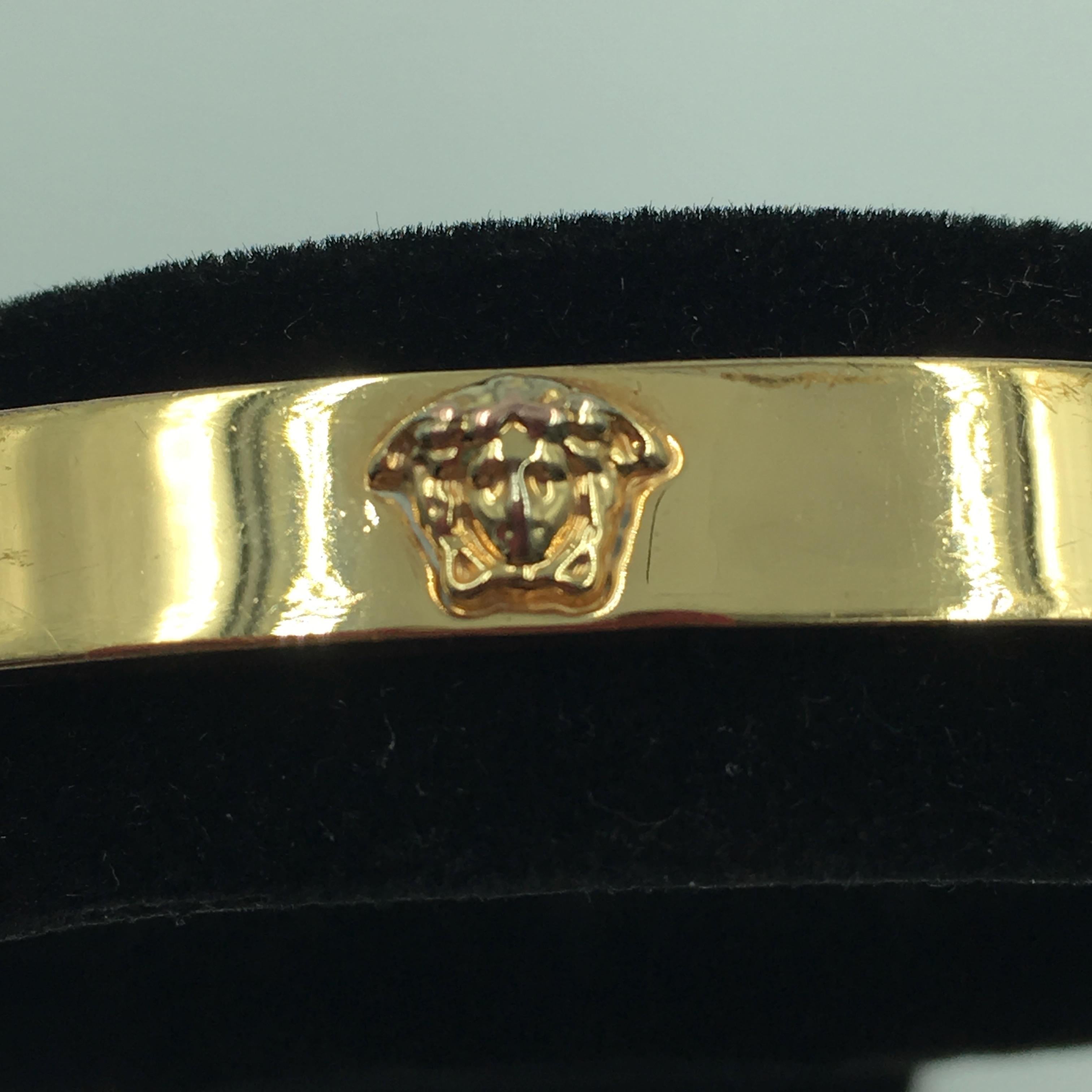 Gianni Versace Gold Plated Medusa Bangle Bracelet. Single Medusa head on top of bracelet. Bracelet has a hidden hook closure.
Good vintage condition.

Outer measurements are as follows:
Width- 2 3/4