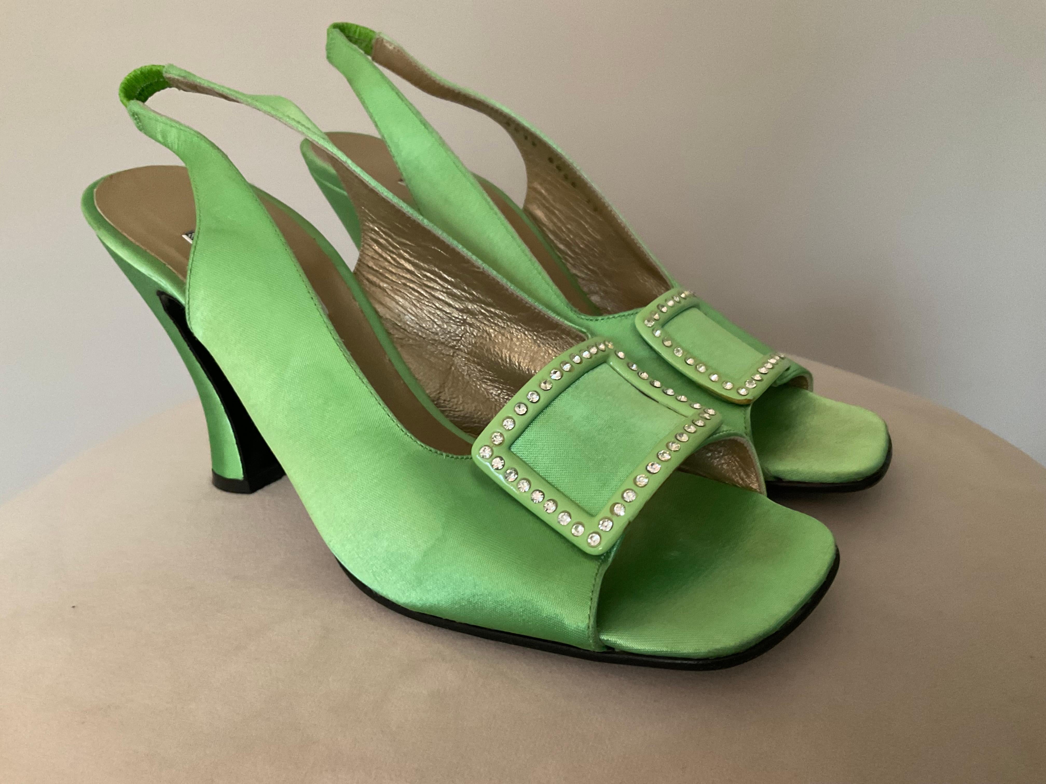 Rari tacchi a spillo in raso verde di Gianni Versace - Passerella Autunno/Inverno 1996.
Entra nella storia della moda con questi splendidi tacchi slingback vintage di Gianni Versace in vibrante raso verde. Questo paio iconico presenta un design