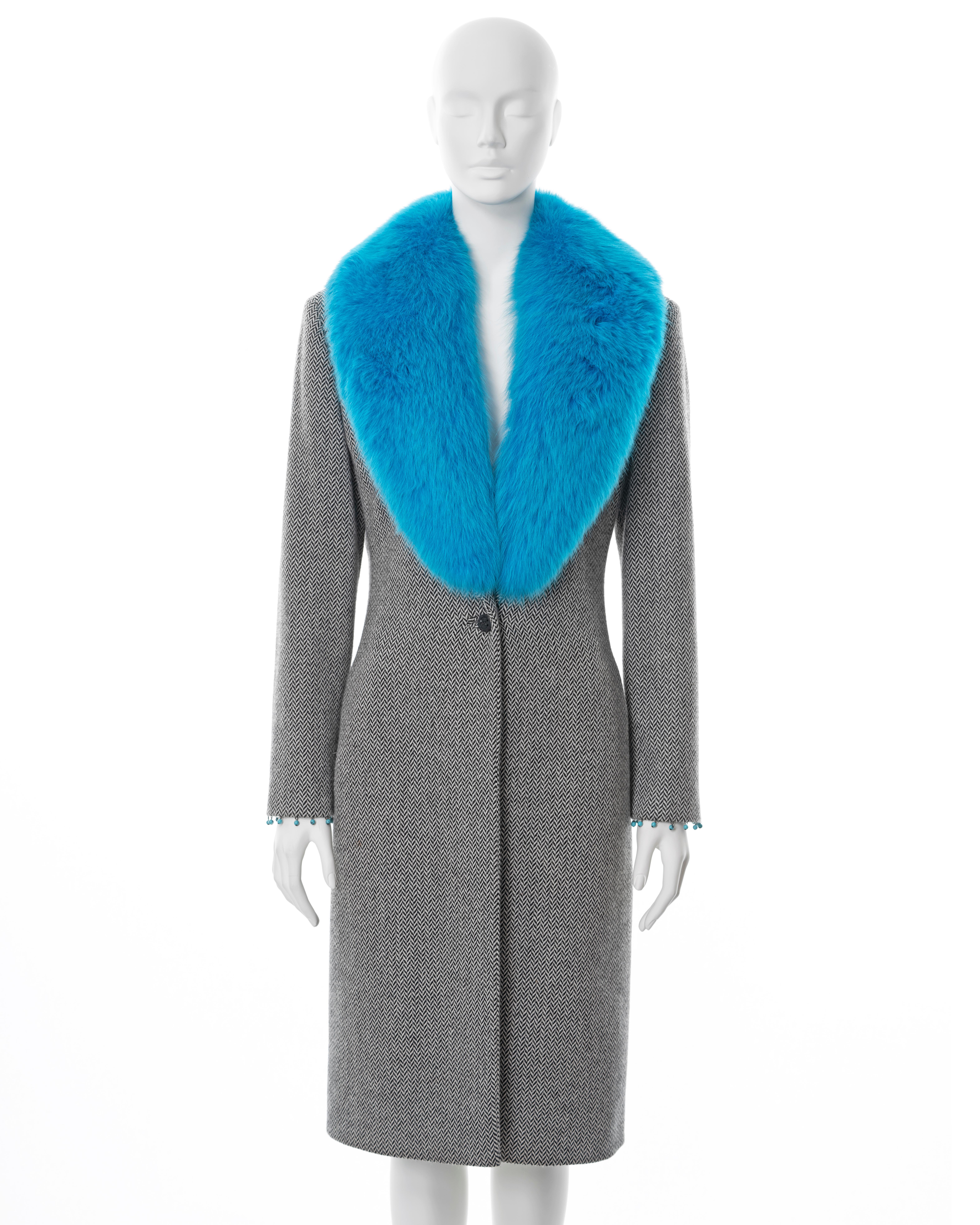 ▪ Gianni Versace tweed coat 
▪ Designed by Donatella Versace
▪ Sold by One of a Kind Archive
▪ Fall-Winter 1999
▪ Constructed from black and white herringbone cashmere-wool tweed 
▪ Detachable blue fox fur collar 
▪ Turquoise bead tassel trim on