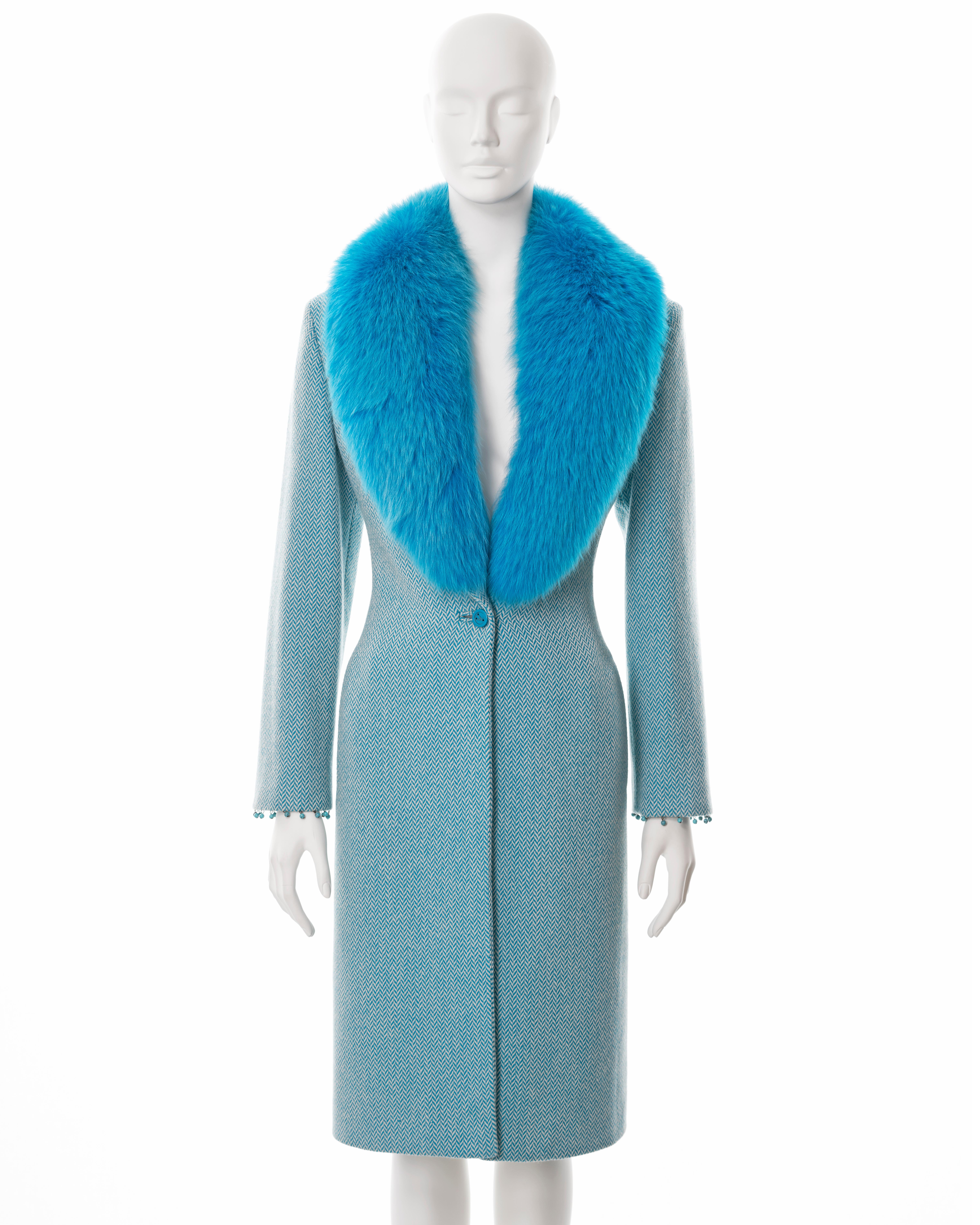 ▪ Gianni Versace tweed coat 
▪ Designed by Donatella Versace
▪ Sold by One of a Kind Archive
▪ Fall-Winter 1999
▪ Constructed from blue and white herringbone cashmere-wool tweed 
▪ Detachable blue fox fur collar 
▪ Turquoise bead tassel trim on