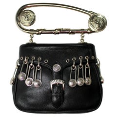 Bolso de piel negro con el icónico imperdible de Gianni Versace, temporada primavera-verano 1994