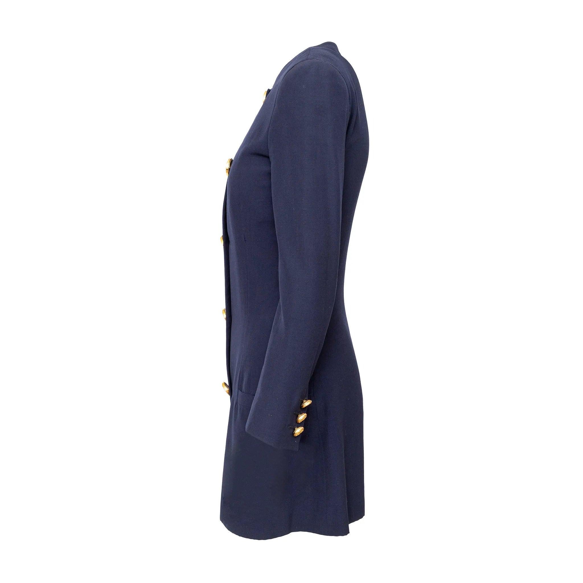 Chaqueta de lana azul marino de Gianni Versace con cintura entallada, cuello redondo y botones decorativos dorados. Se puede llevar como un vestido chic para un look elegante y entallado.
 Observaciones: Falta esmalte en un botón, faltan algunas