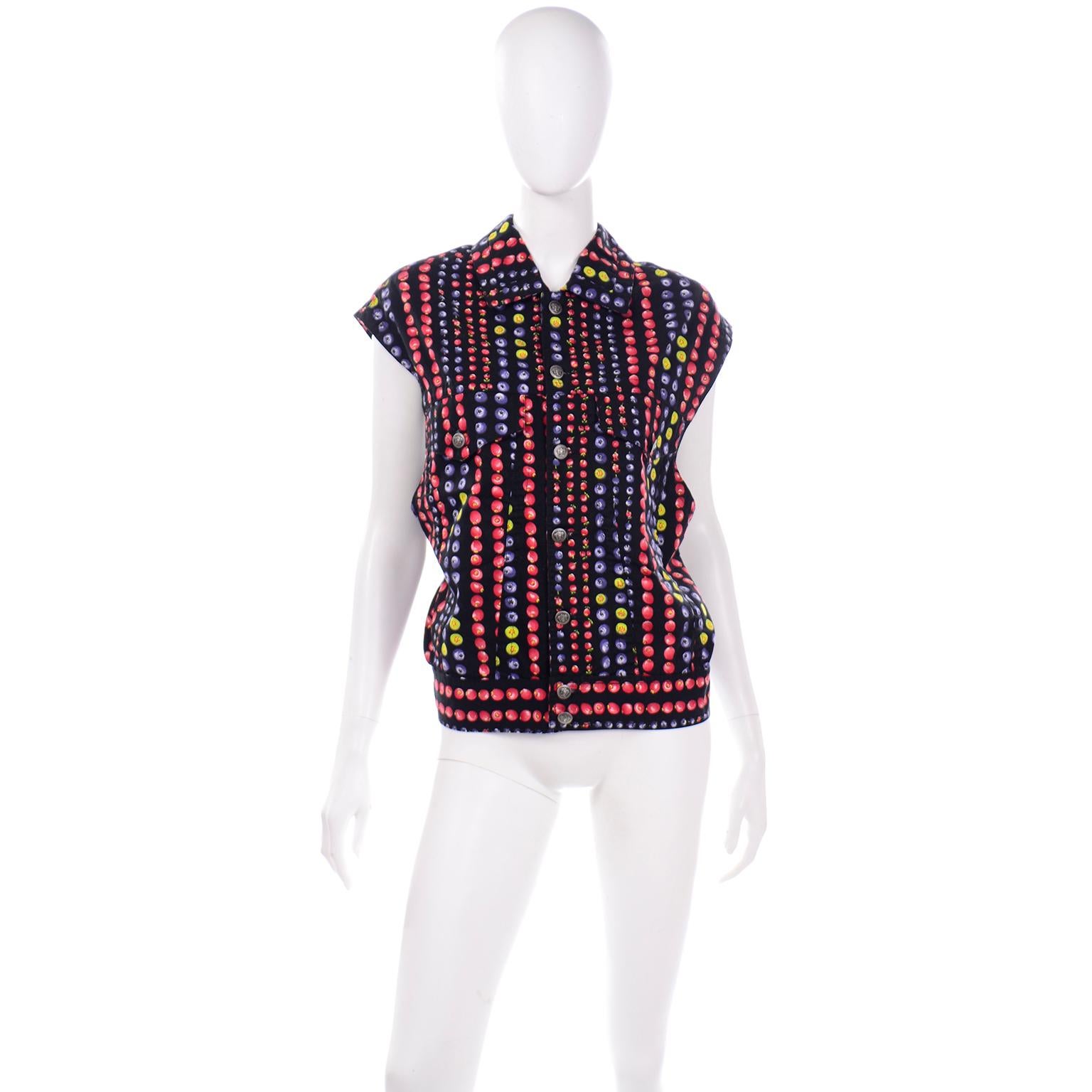 This is a unique cotton fruit printed denim vest with the Versace Jeans Couture label from 1995. The base color of this vest is black and has vertical stripes that feature multi colored fruits in shades of blue, red, yellow, and green. The vest has