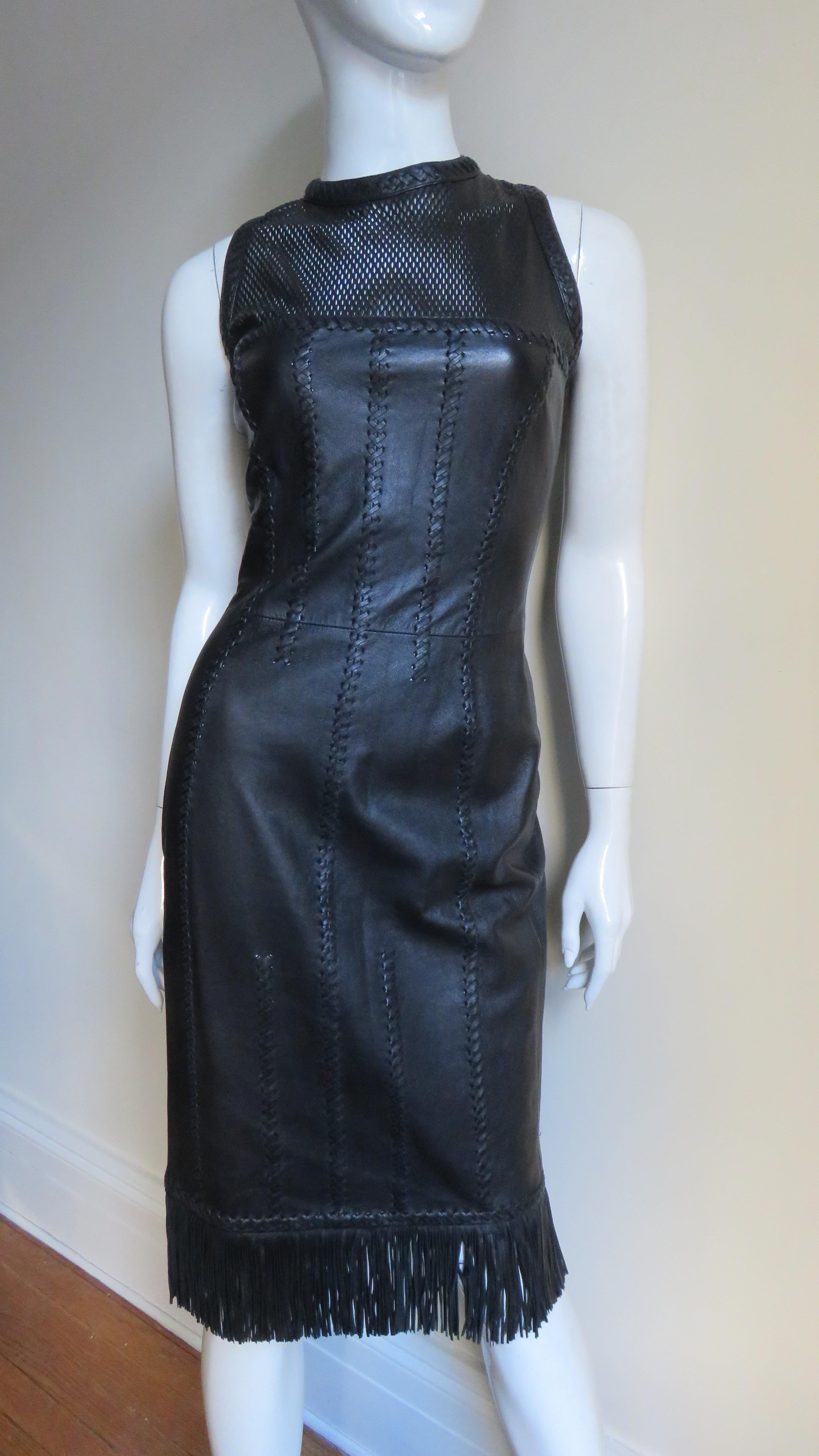 An extraordinary and collectible supple black leather dress from Gianni Versace. This has all of the couture details Versace is known for- a fine fringe hem, laser perforated leather at the upper chest and elaborate seaming highlighted with leather