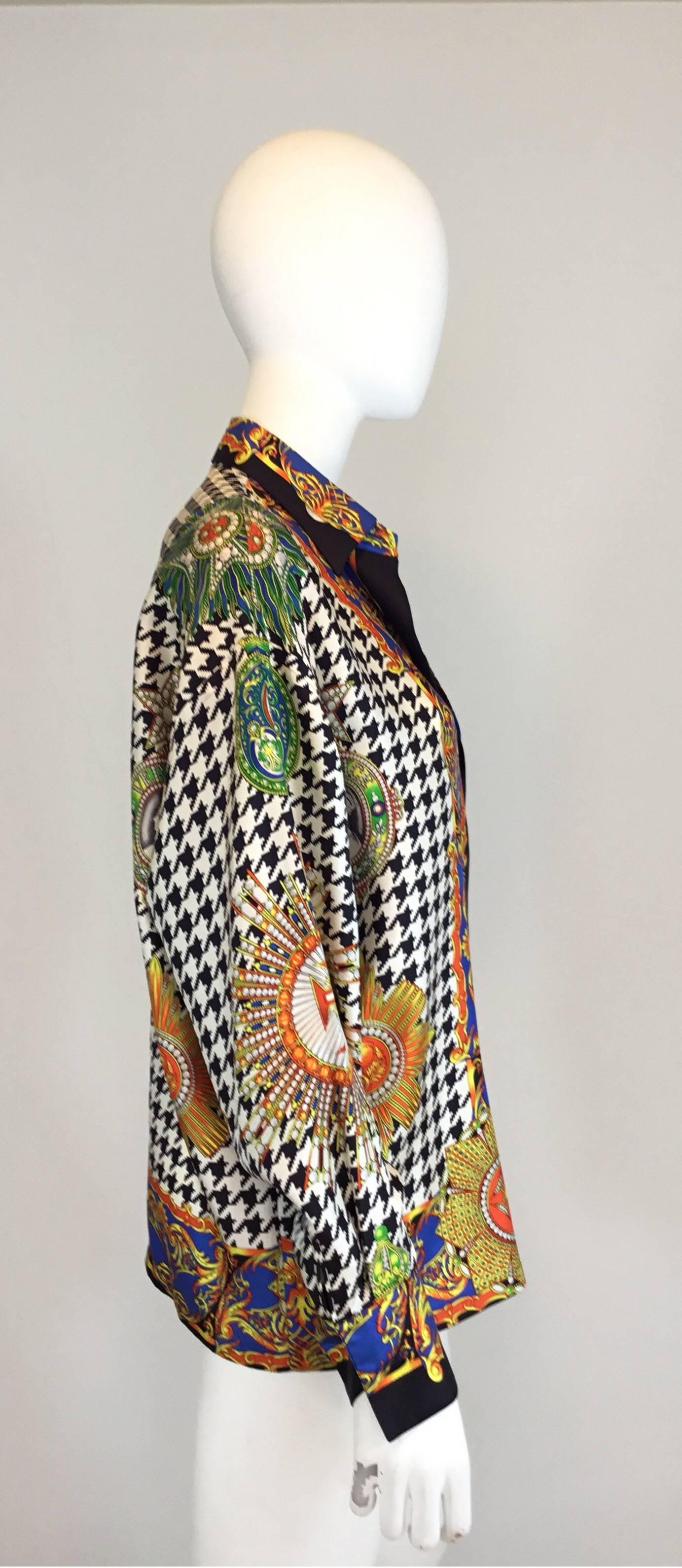 Vintage Versace blouse made of 100% silk features a vibrant and sharp print throughout with button closures along the front and on the cuffs. Bold graphic print. Boxy slouchy oversized fit. Miami era lifetime Versace. Made in Italy.

bust-