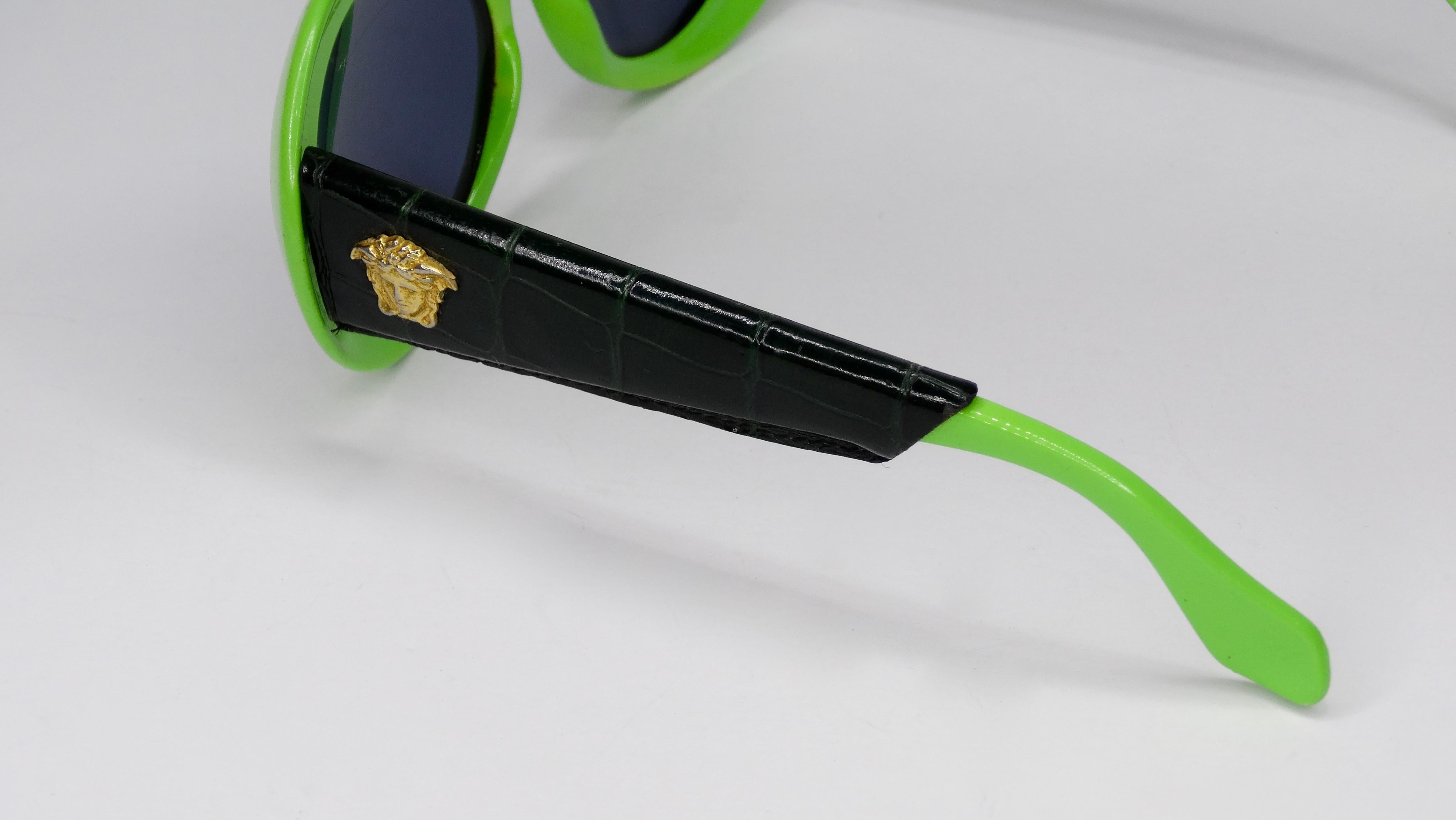 Your new favorite accessory! Circa late 1980s/early 1990s, these amazing sunglasses feature a lime green oval frame with leather black crocodile embossed arms and a Medusa head. The perfect pop of color for all your Versace looks! Comes with case.