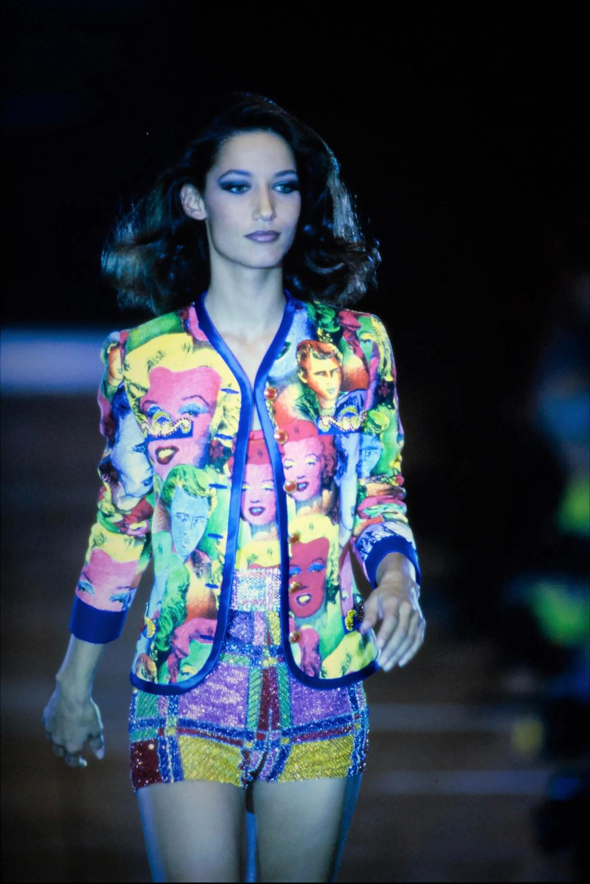 Combinaison jupe Gianni Versace Couture en excellent état, datant du printemps-été 1991, avec un motif pop art inspiré d'Andy Warhol représentant les icônes de la culture pop Marilyn Monroe et James Dean. 
Comme vu sur le défilé printemps-été 1991