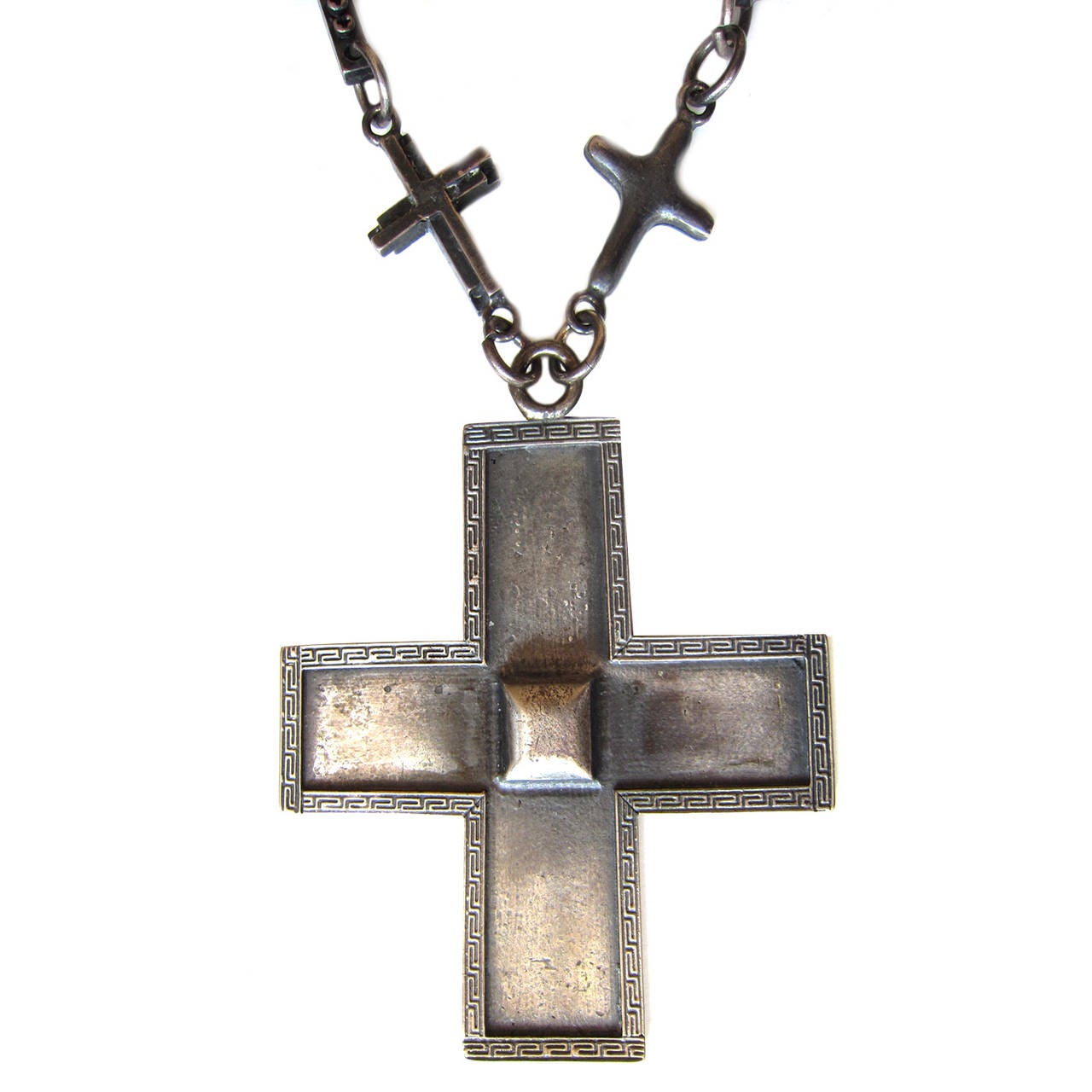 Rare Gianni Versace necklace with massive cross.　　
Bronze tone large cross has iconic Gianni Versace greek key border with different cross motif chains. 
Measurements :
Main Cross : 10 cm x 10 cm
Chain Cross : circa 4 cm 
Total Chain Length : 56 cm