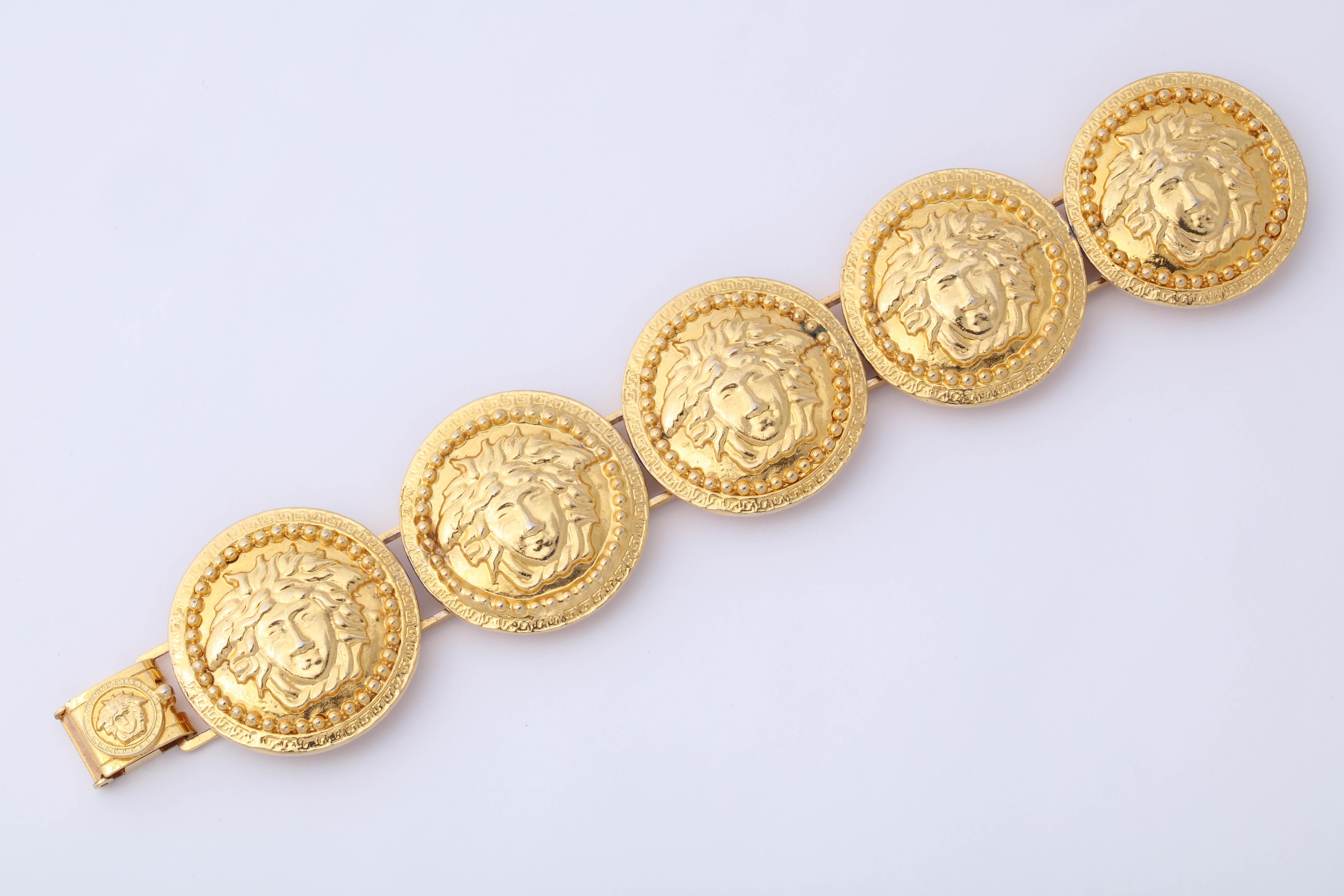 Gianni Versace gold toned bracelet with 5 iconic Medusas motifs.