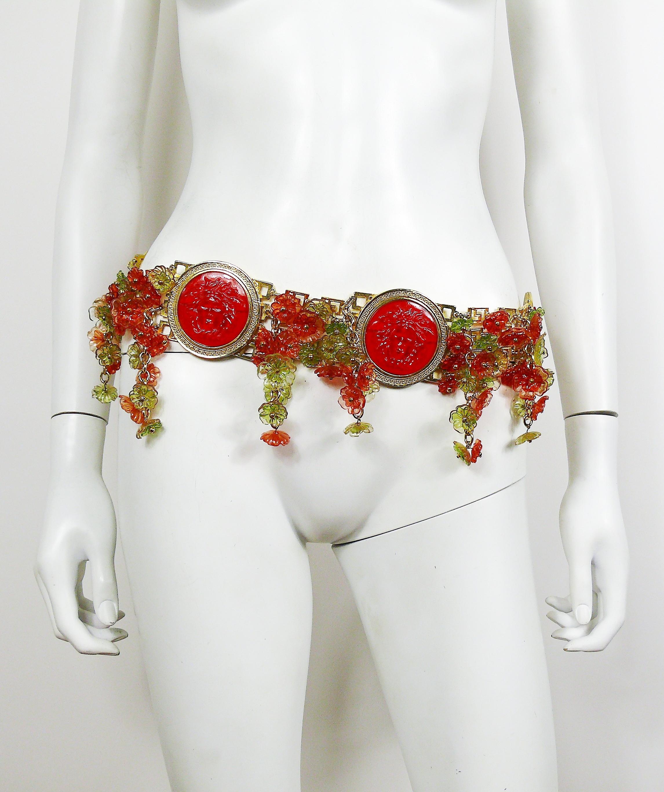 GIANNI VERSACE iconic quadruple gold toned greca motif belt featuring massive red resin Medusa head medallions and multicolored resin flowers embellishement.

1993 Spring/Summer Collection.
Similar belt (in black version) worn by super model YASMEEN