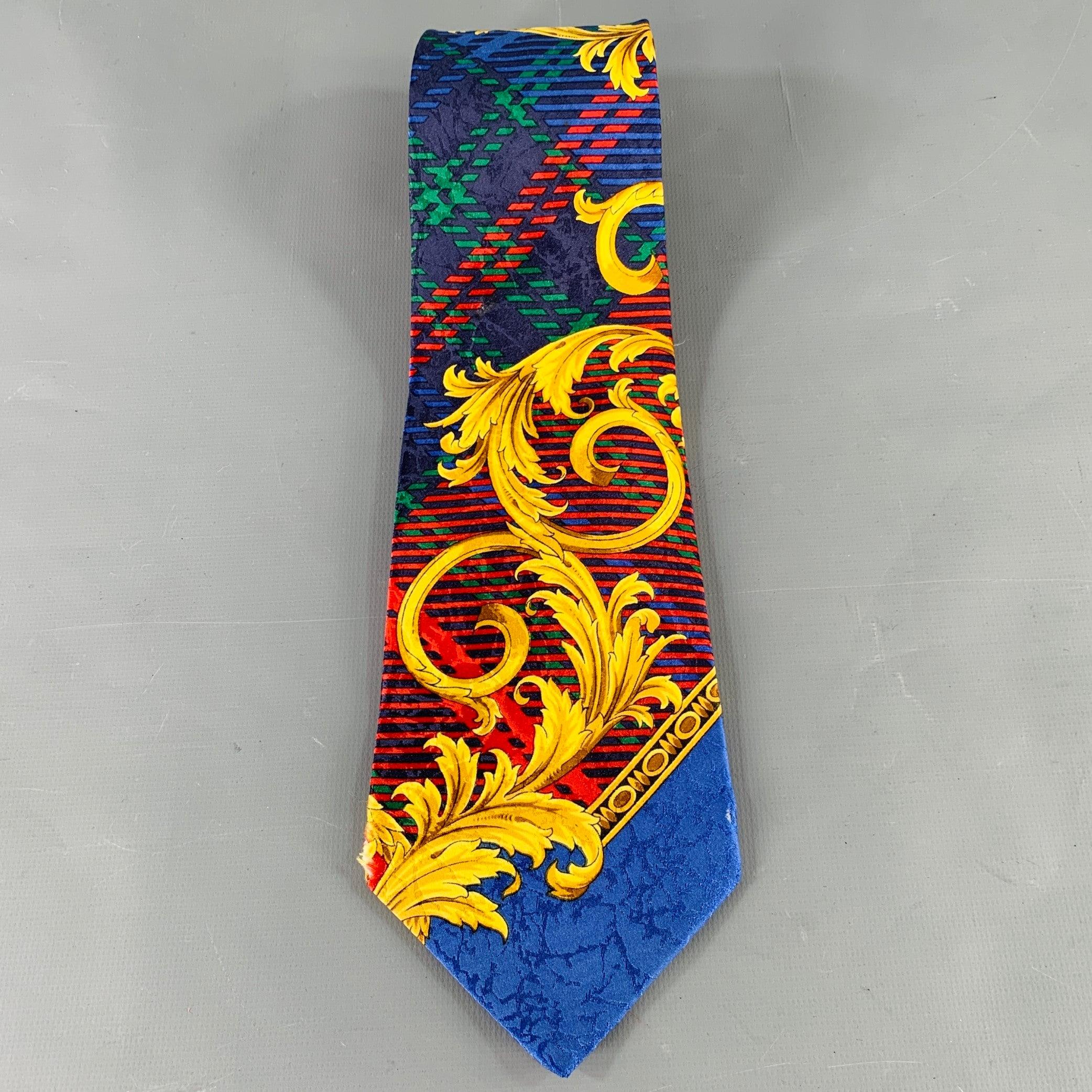 Vintage GIANNI VERSACE necktie
in a multi-color silk featuring a baroque print on mixed patterns background. Made in Italy.Very Good Pre-Owned Condition.
Signs of wear on corners consistent with vintage condition.Width: 4 inches Length: 59 inches 
